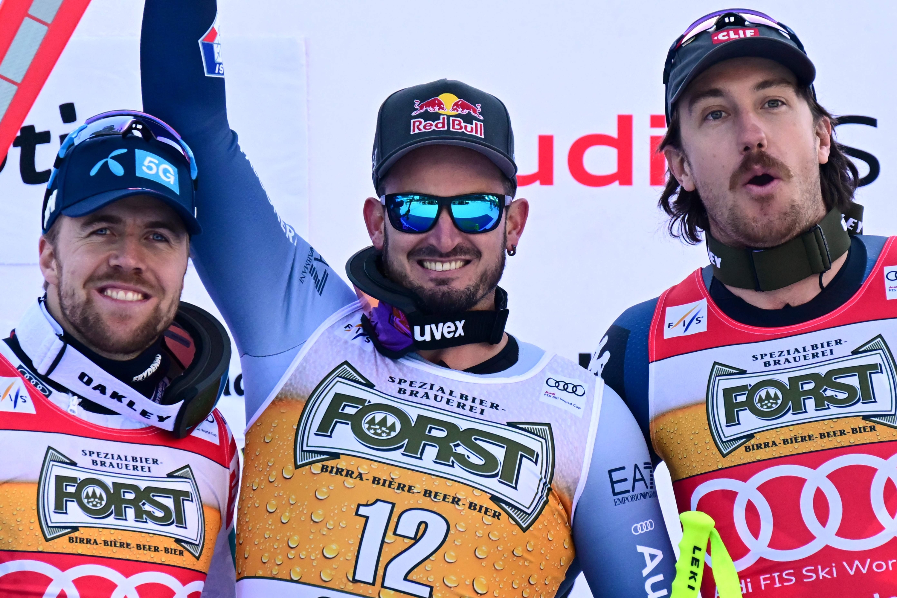 First placed Italian Dominik Paris (C), second placed Norwegian Aleksander Aamodt Kilde (L) and third placed US' Bryce Bennett pose on the podium after winning the men's Downhill during the FIS Alpine Ski World Cup in Val Gardena on December 16, 2023. (Photo by Tiziana FABI / AFP)