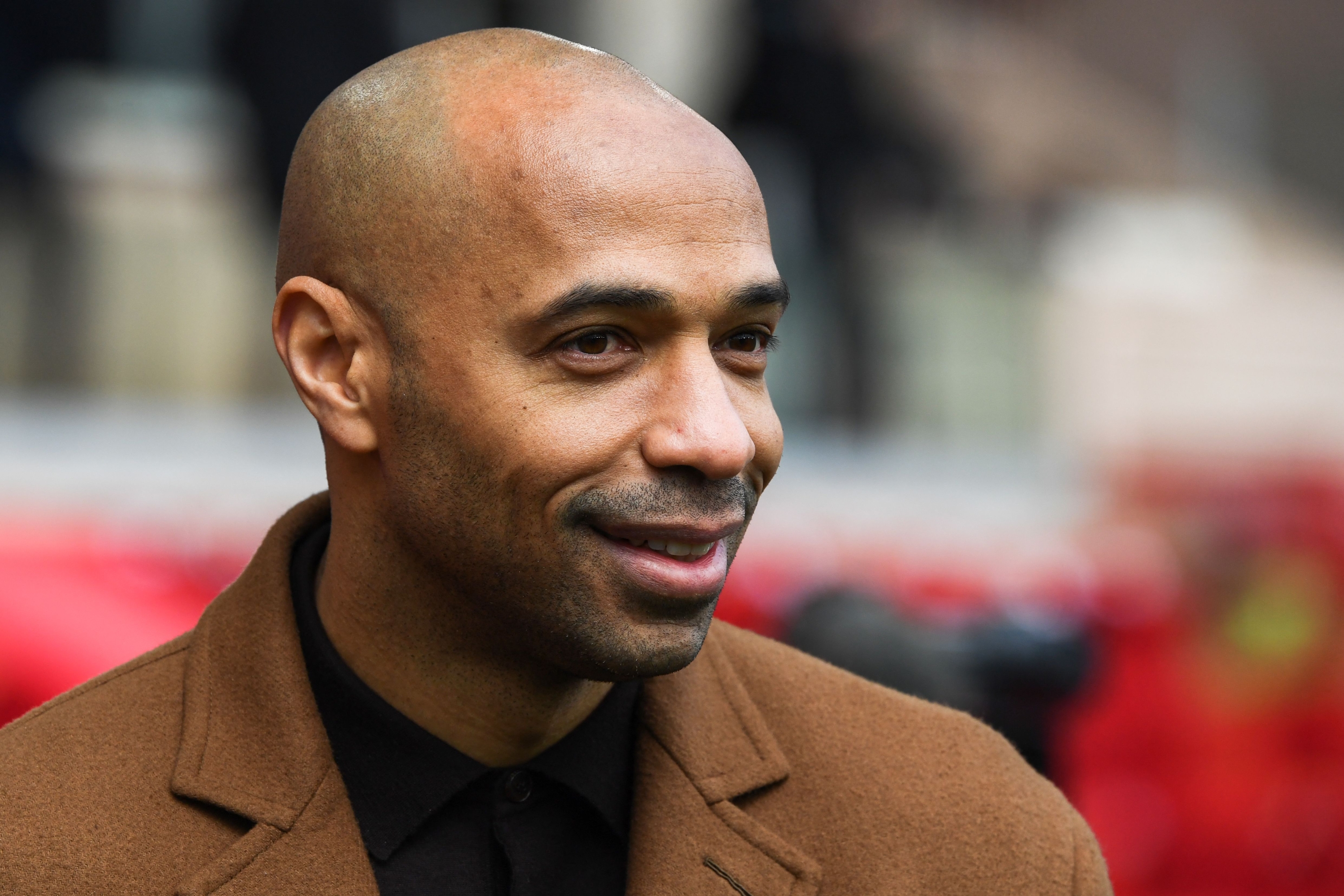 Former French player and TV host Thierry Henry smiles ahead of the French L1 football match between AS Monaco and Paris Saint Germain (PSG) at the Louis II Stadium (Stade Louis II) in the Principality of Monaco on March 20, 2022. (Photo by CLEMENT MAHOUDEAU / AFP)