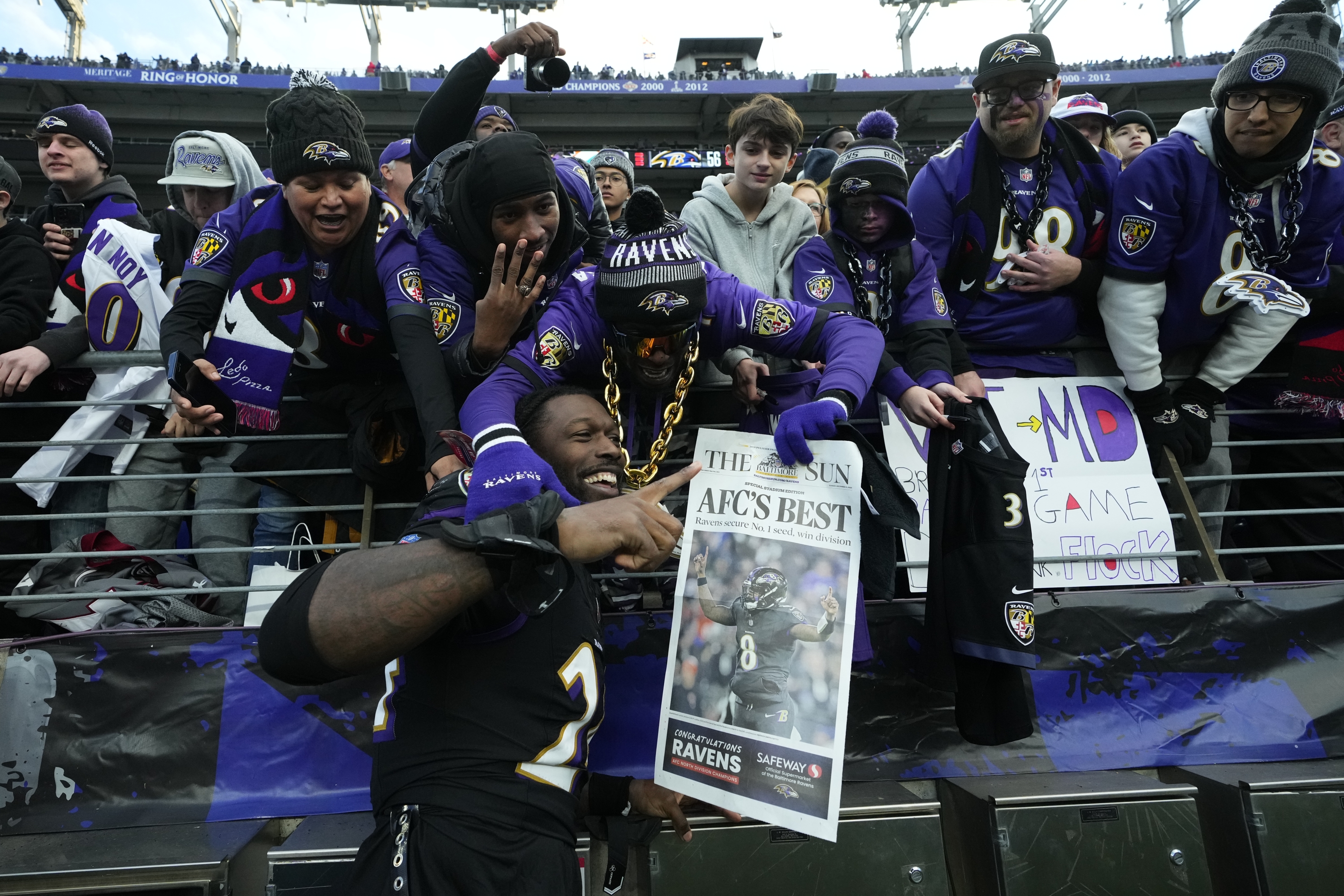 Baltimore Ravens linebacker Jadeveon Clowney, bottom, celebrates with fans after an NFL football game against the Miami Dolphins in Baltimore, Sunday, Dec. 31, 2023. (AP Photo/Matt Rourke)