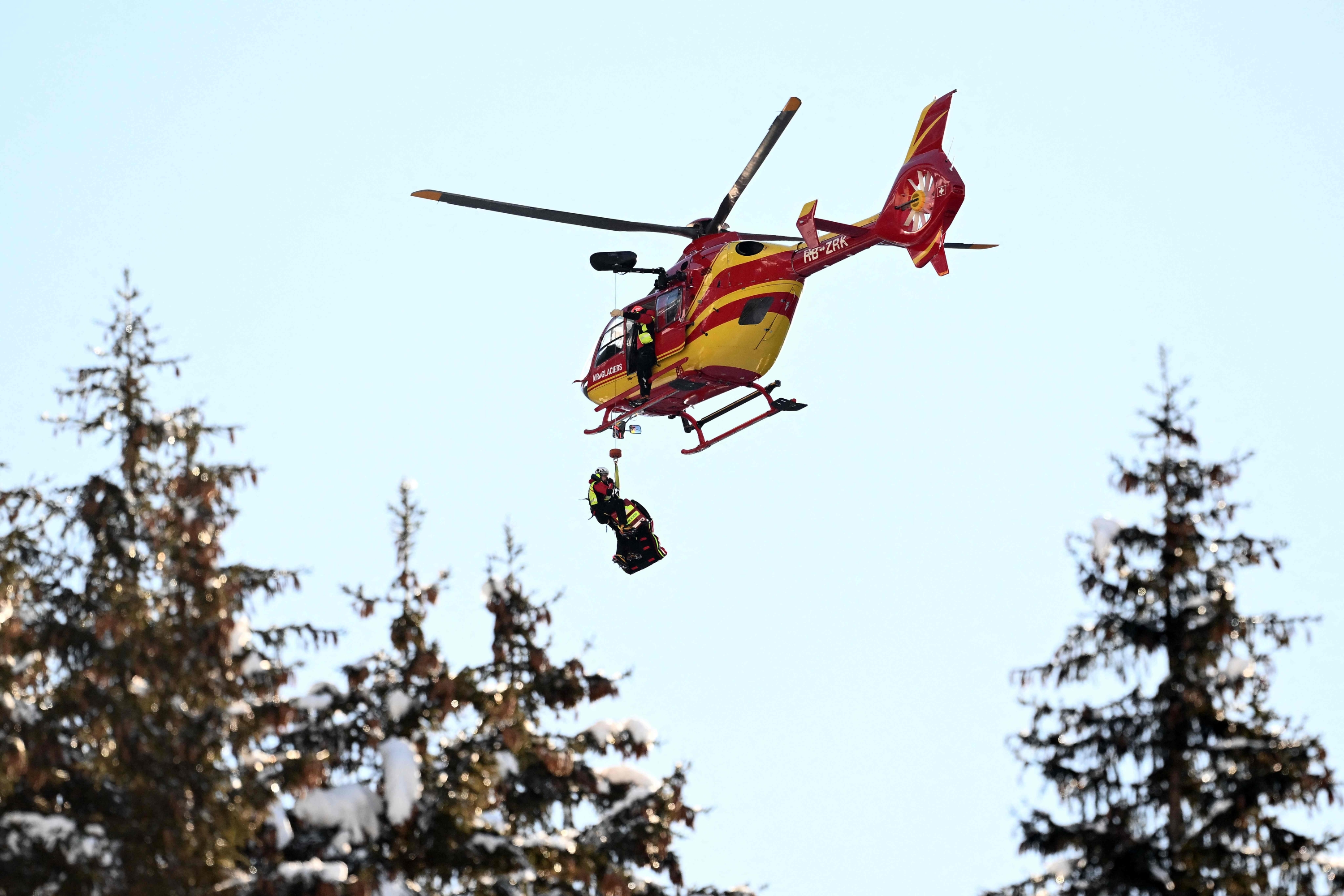 Rescuers arrive with a helicopter to evacuate France's Alexis Pinturault after he crashed during the men's Super-G event at the FIS Alpine Skiing World Cup event in Wengen on January 12, 2024. (Photo by Marco BERTORELLO / AFP)