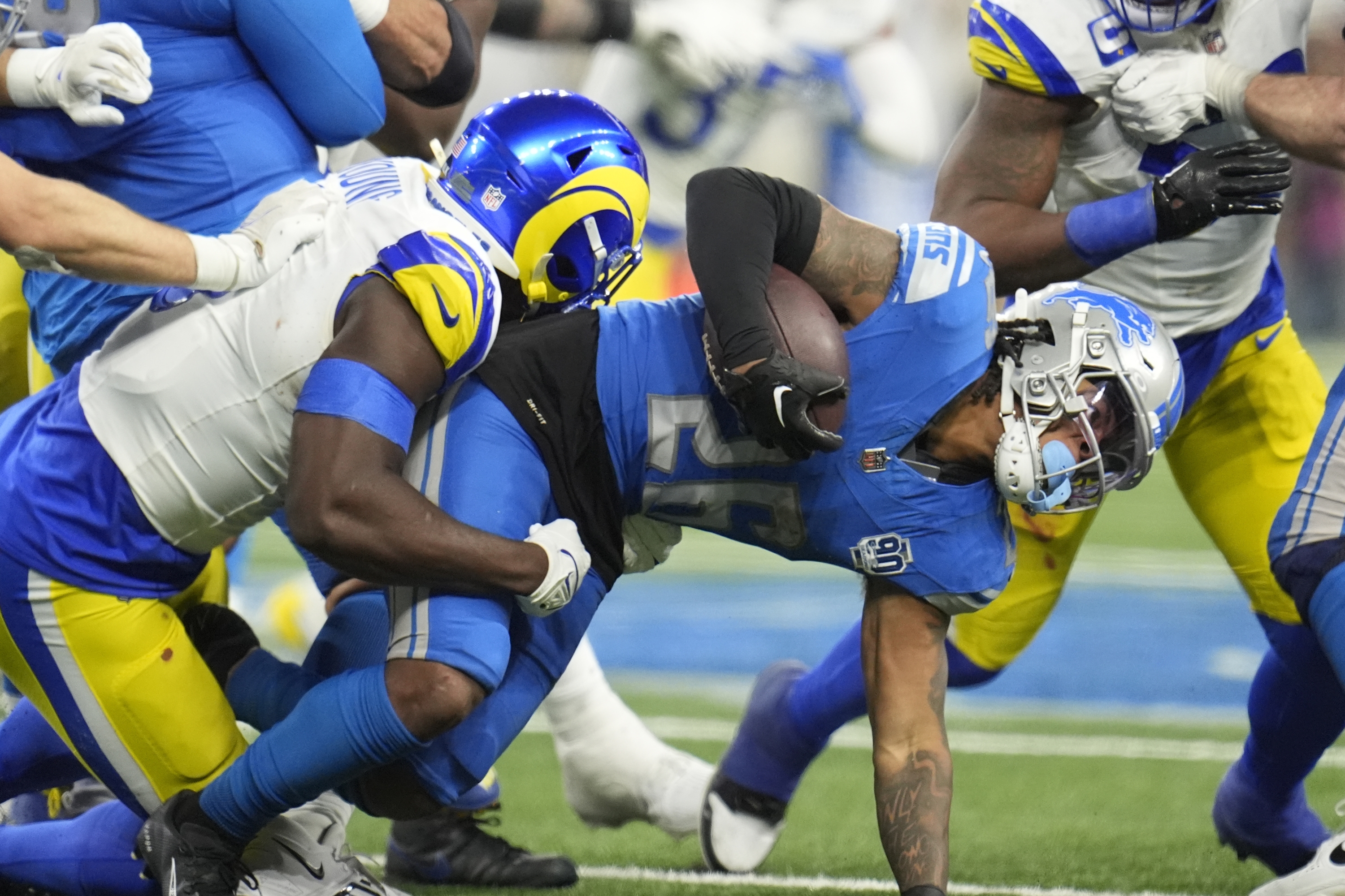 Detroit Lions running back Jahmyr Gibbs is stopped during the second half of an NFL wild-card playoff football game against the Los Angeles Rams, Sunday, Jan. 14, 2024, in Detroit. (AP Photo/Paul Sancya)