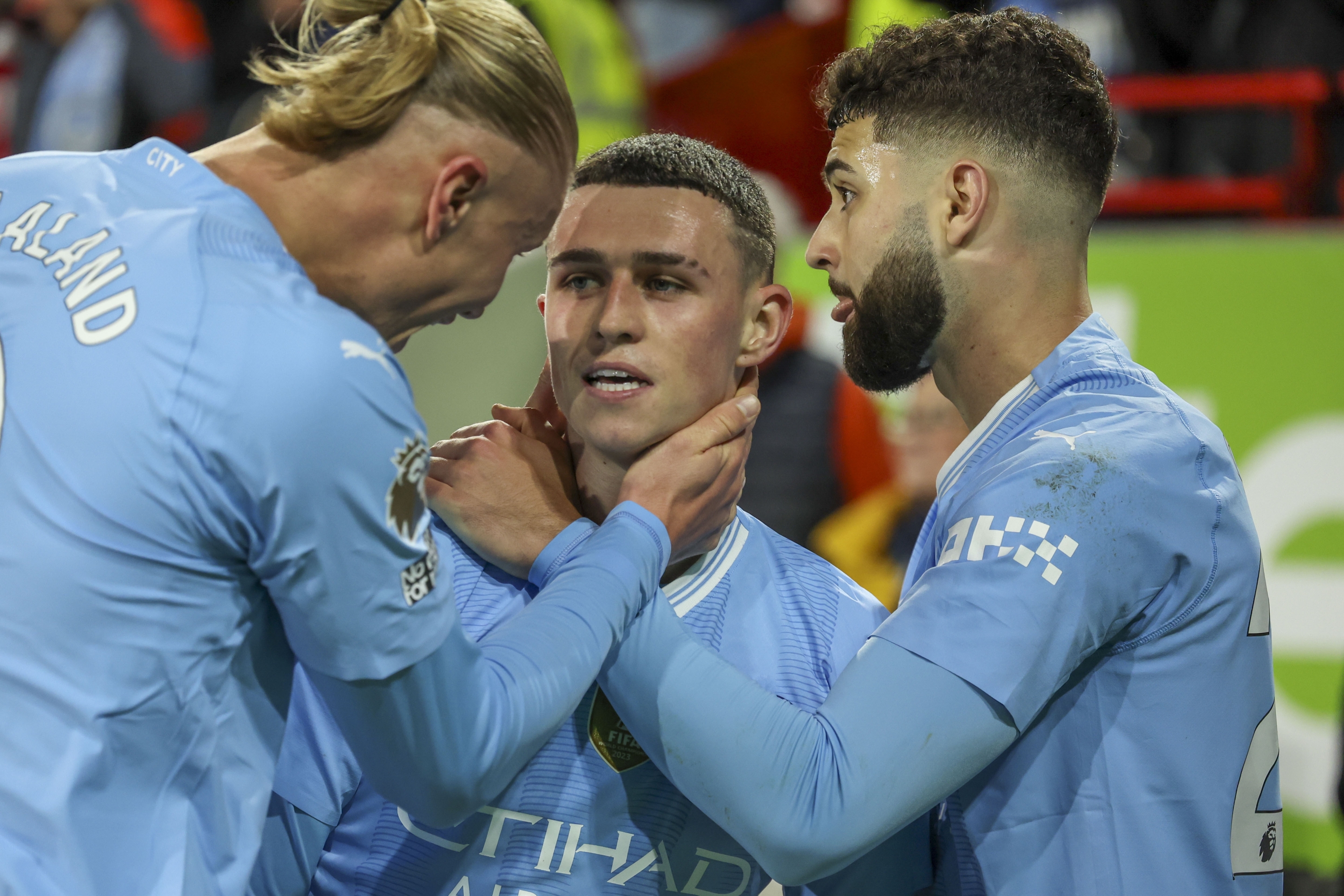 Manchester City's Phil Foden, center, celebrates eith Manchester City's Erling Haaland, left, and Manchester City's Josko Gvardiol after scoring his side's third goal during the English Premier League soccer match between Brentford and Manchester City at the Gtech Community Stadium in London, Monday, Feb. 5, 2024. (AP Photo/Ian Walton)