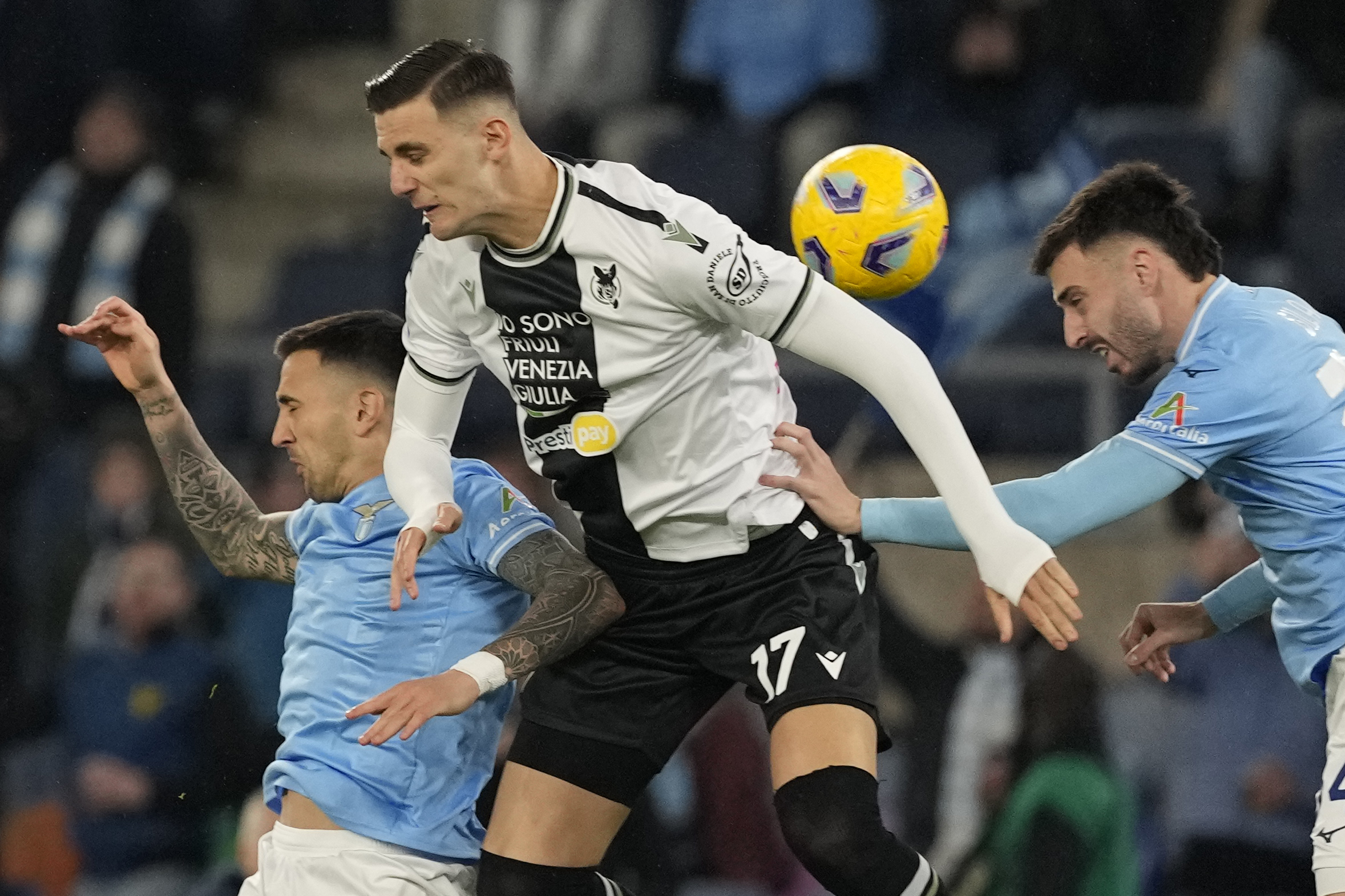 Udinese's Lorenzo Lucca, center, challenges for the ball with Lazio's Matias Vecino, left and his teammate Patric during a Serie A soccer match between Lazio and Udinese, at Rome's Olympic Stadium, Monday, March 11, 2024. (AP Photo/Andrew Medichini)