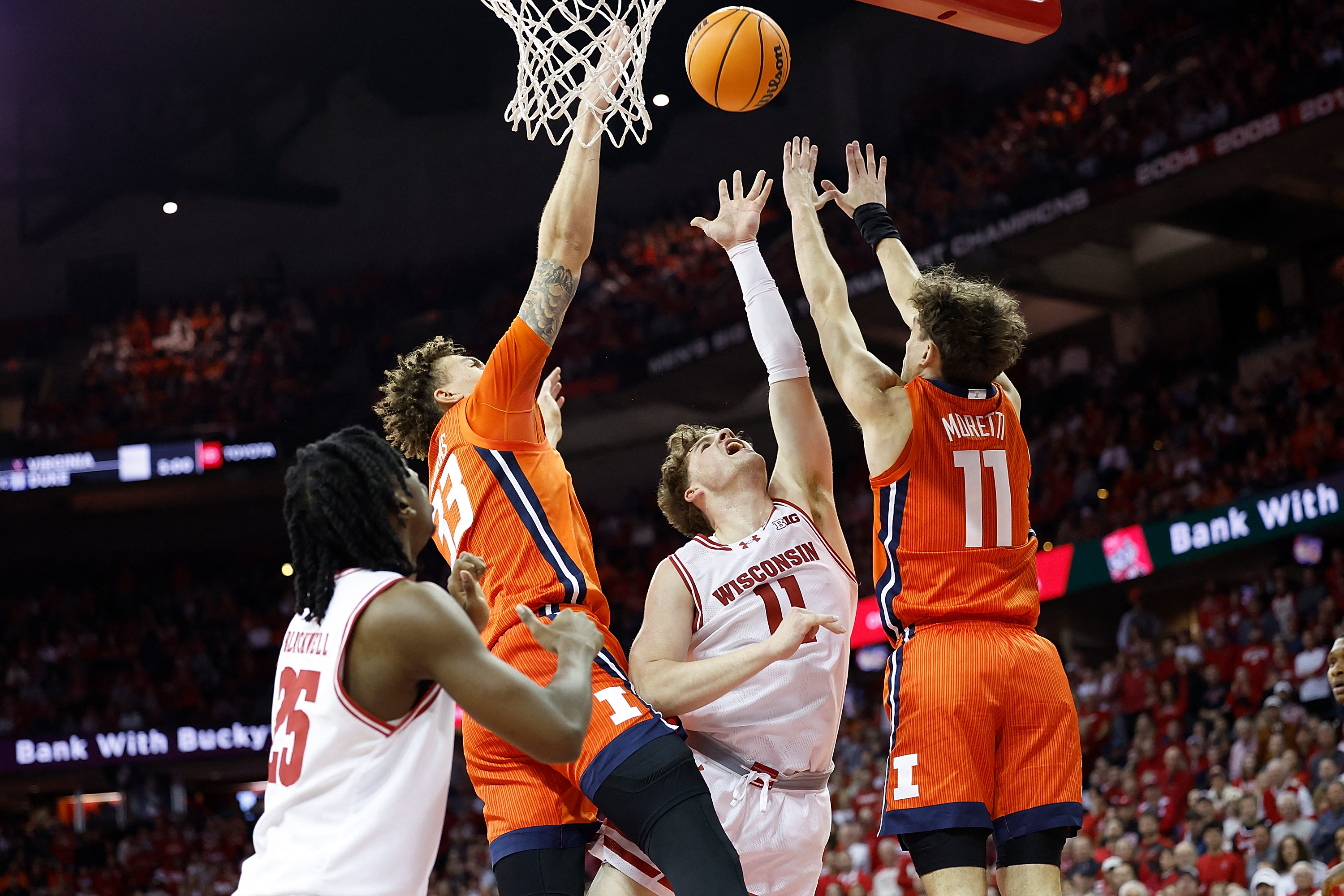 MADISON, WISCONSIN - MARCH 02: Max Klesmit #11 of the Wisconsin Badgers goes up for a shot between Niccolo Moretti #11 and Quincy Guerrier #13 of the Illinois Fighting Illini in the second half of the game at Kohl Center on March 02, 2024 in Madison, Wisconsin.   John Fisher/Getty Images/AFP (Photo by John Fisher / GETTY IMAGES NORTH AMERICA / Getty Images via AFP)