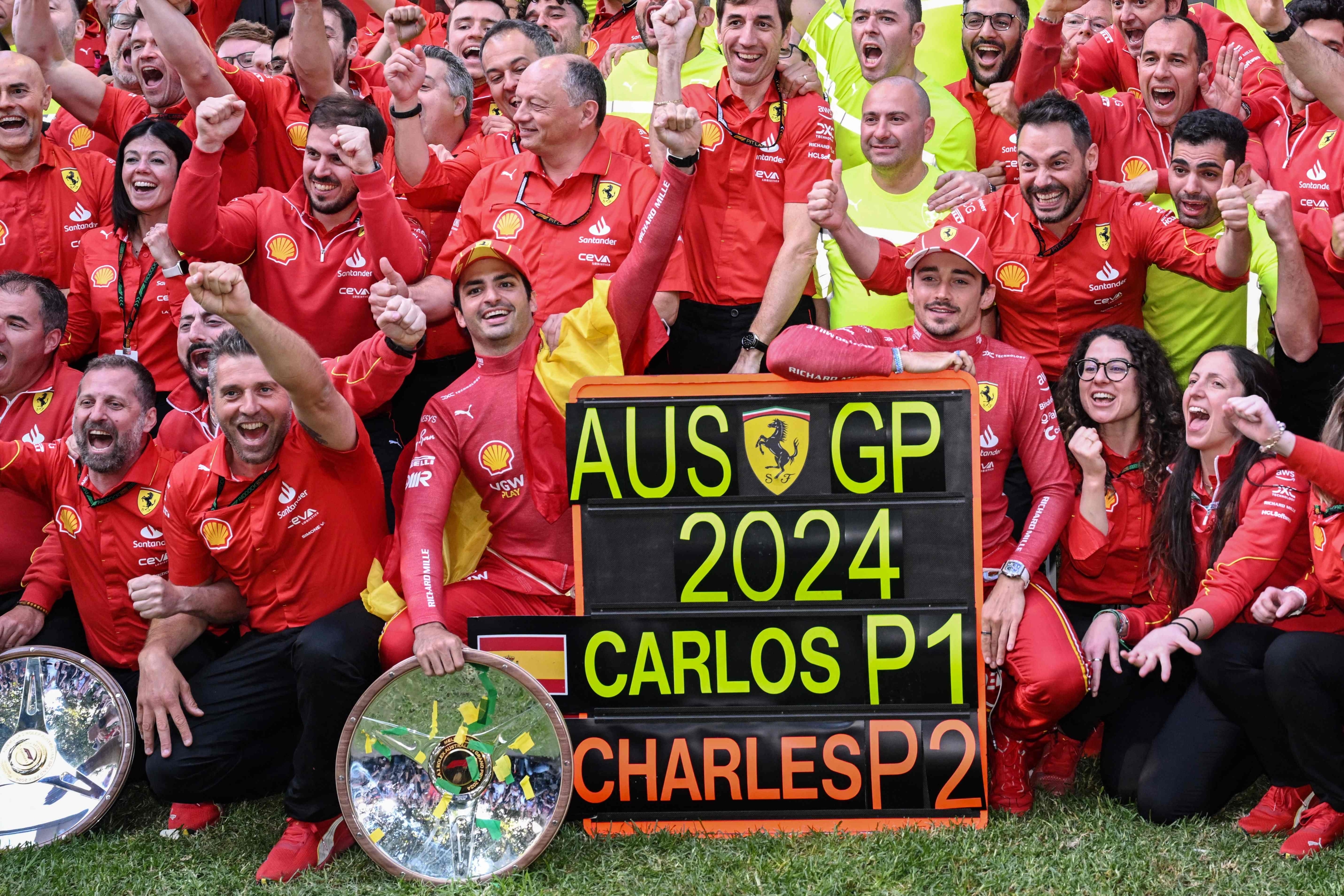 TOPSHOT - Winner Ferrari's Spanish driver Carlos Sainz Jr (front centre L) and second-placed Ferrari's Monegasque driver Charles Leclerc (front centre R) celebrate with their team after the Australian Formula One Grand Prix at Albert Park Circuit in Melbourne on March 24, 2024. (Photo by WILLIAM WEST / AFP) / -- IMAGE RESTRICTED TO EDITORIAL USE - STRICTLY NO COMMERCIAL USE --