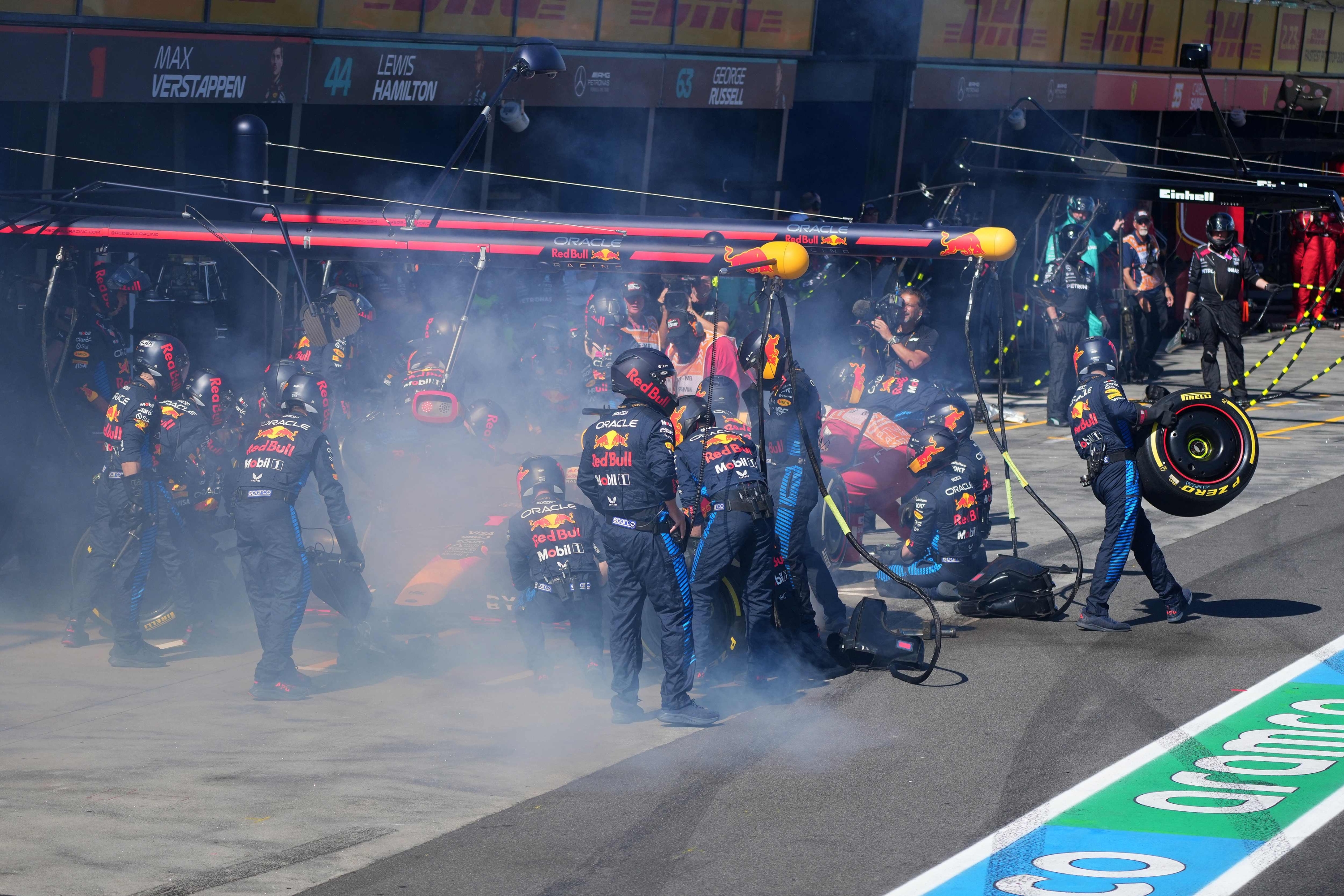 Mechanics deal with the smoke coming out of Red Bull Racing's Dutch driver Max Verstappen car during the Australian Formula One Grand Prix at Albert Park Circuit in Melbourne on March 24, 2024. (Photo by Scott Barbour / POOL / AFP) / -- IMAGE RESTRICTED TO EDITORIAL USE - STRICTLY NO COMMERCIAL USE --