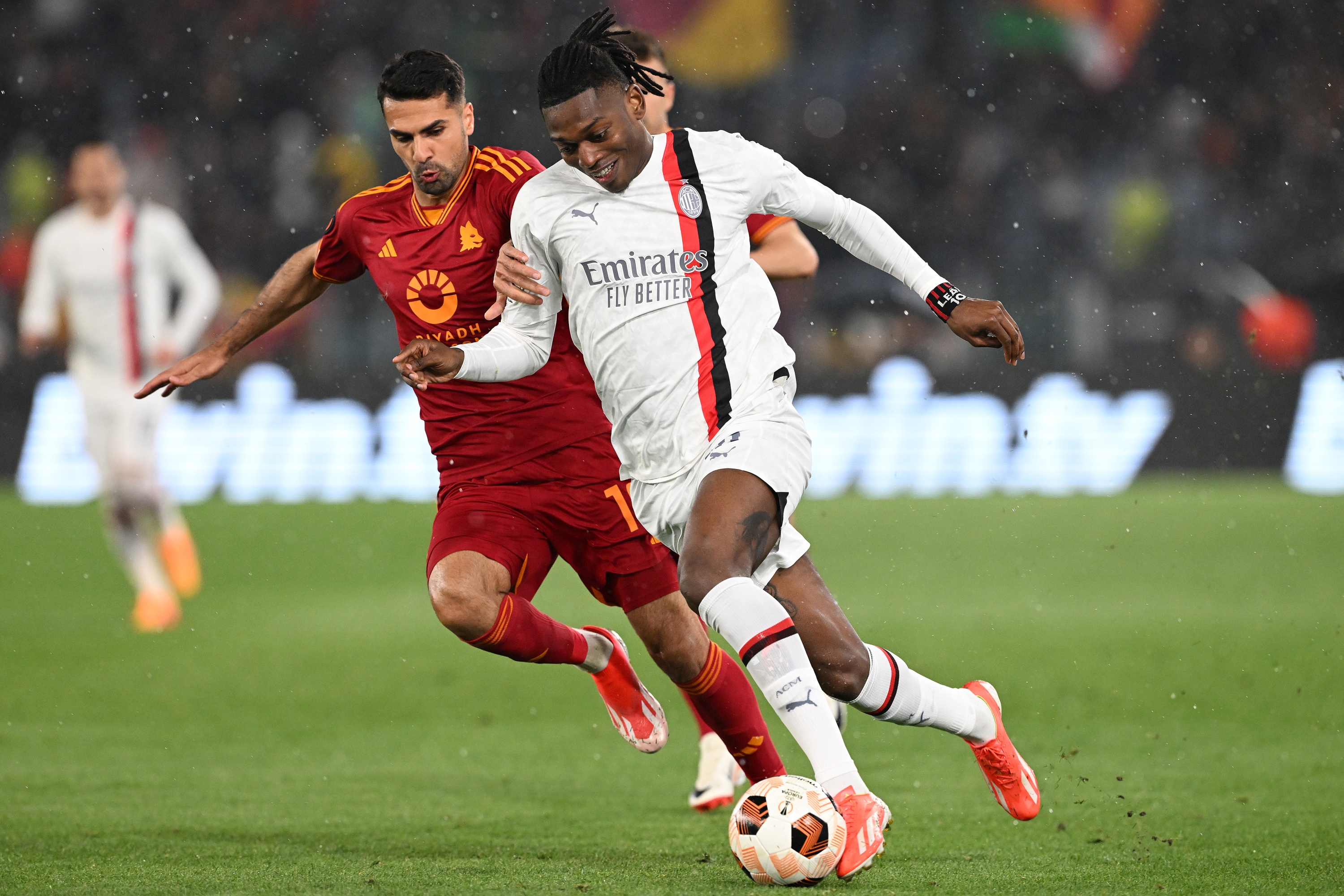 ROME, ITALY - APRIL 18: Rafael Leao of AC Milan battles for possession with Zeki Celik of AS Roma during the UEFA Europa League 2023/24 Quarter-Final second leg match between AS Roma and AC Milan at Stadio Olimpico on April 18, 2024 in Rome, Italy. (Photo by Francesco Pecoraro - AC Milan/AC Milan via Getty Images)