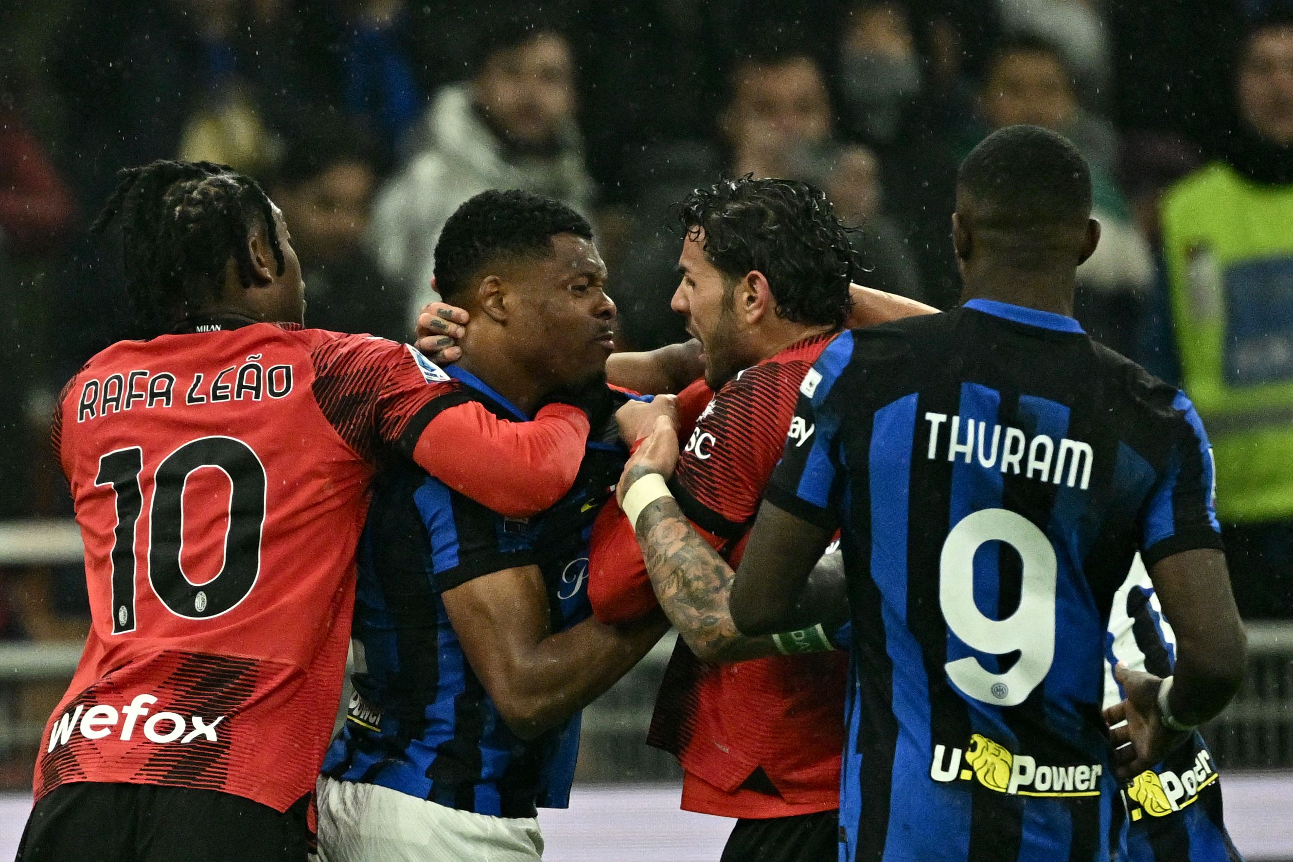 AC Milan's French defender #19 Theo Hernandez (C-R)) fights with Inter Milan's Dutch defender #02 Denzel Dumfries (2C-L) during the Italian Serie A football match between AC Milan and Inter Milan at the San Siro Stadium in Milan on April 22, 2024. (Photo by GABRIEL BOUYS / AFP)