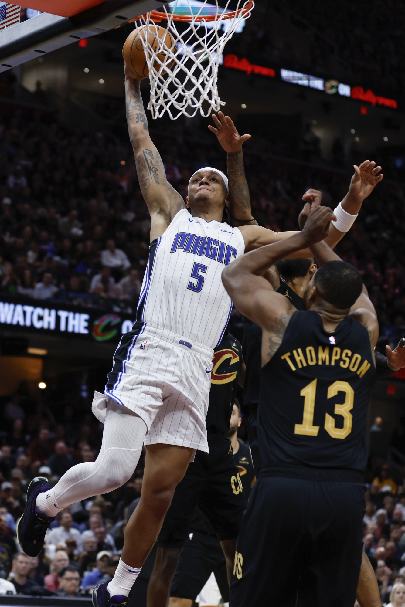 Orlando Magic forward Paolo Banchero (5) dunks against Cleveland Cavaliers center Tristan Thompson (13) during the second half of Game 5 of an NBA basketball first-round playoff series, Tuesday, April 30, 2024, in Cleveland. (AP Photo/Ron Schwane)