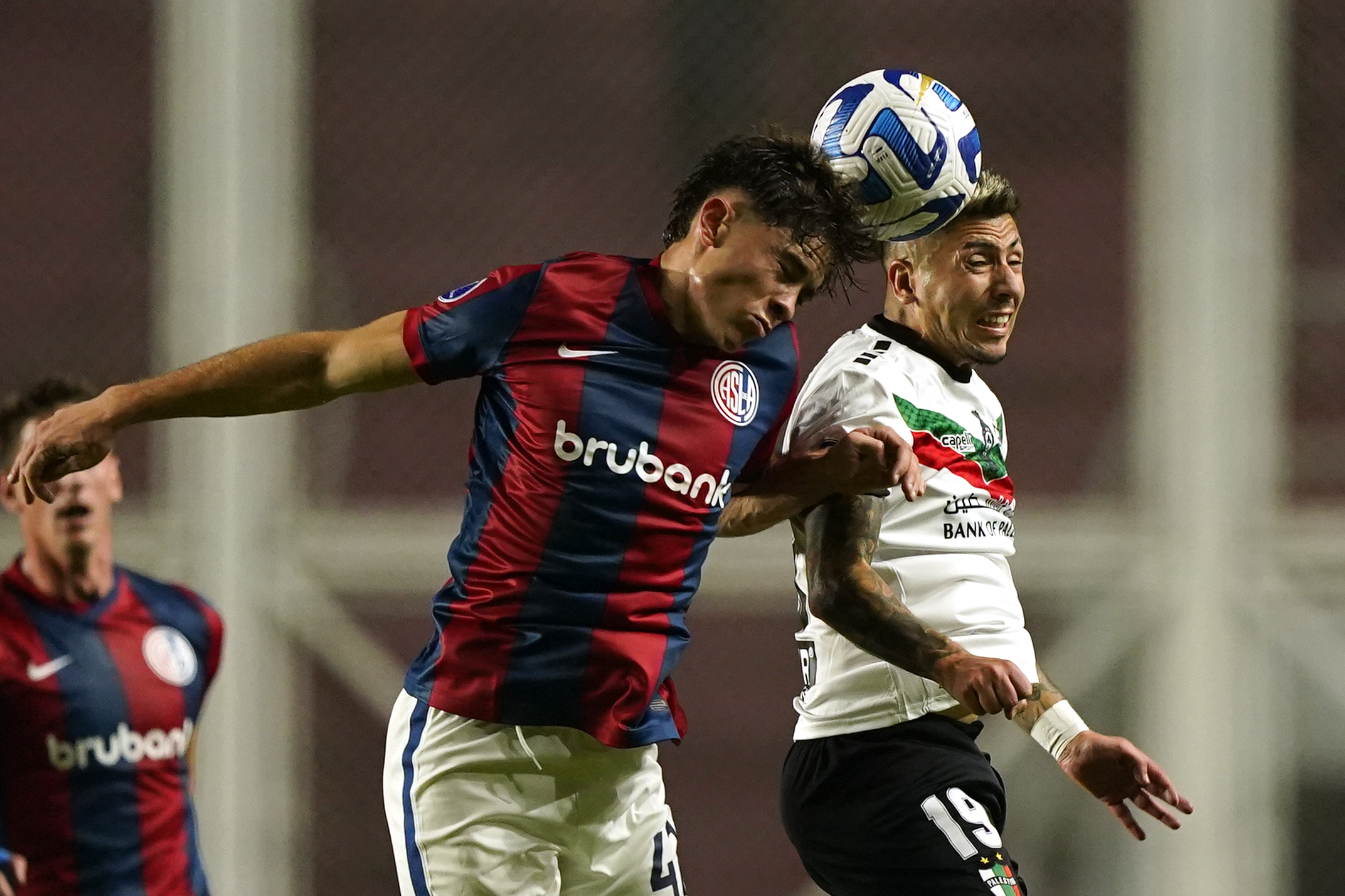 Agustin Giay del San Lorenzo dell'Argentina, a sinistra, e Brayan Bejar del Palestino del Cile, saltano per un colpo di testa durante una partita di calcio del Gruppo H della Copa Sudamericana a Buenos Aires, Argentina, giovedì 8 giugno 2023. (AP Photo/Ivan Fernandez)