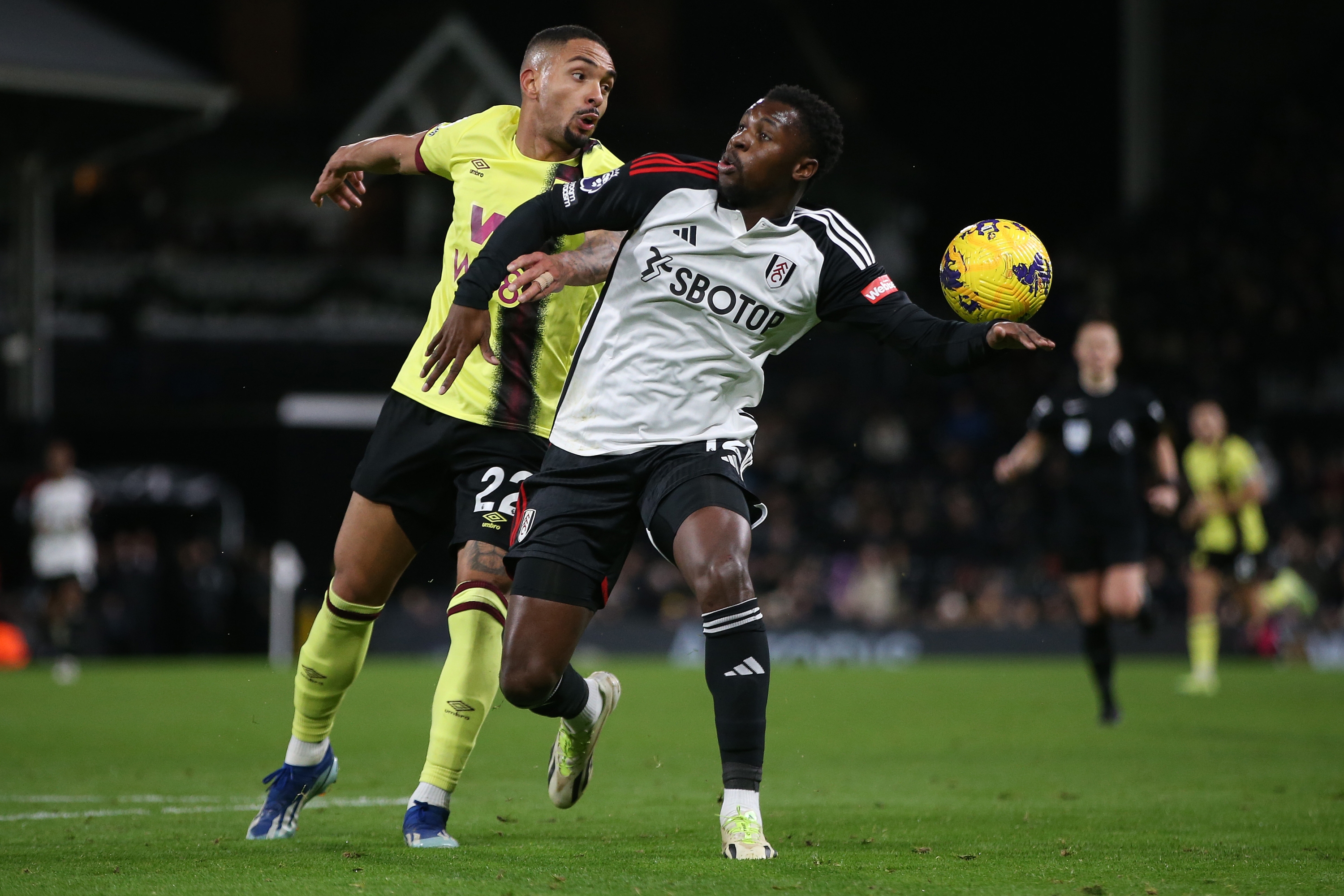 LONDON, ENGLAND - DECEMBER 23: Vitinho of Burnley and Fode Ballo-Toure of Fulham challenge for the ball during the Premier League match between Fulham FC and Burnley FC at Craven Cottage on December 23, 2023 in London, England. (Photo by Steve Bardens/Getty Images)