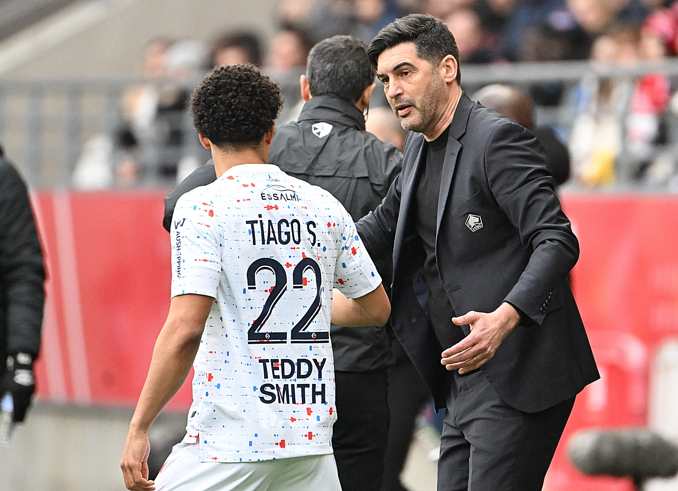 Lille's Portuguese head coach Paulo Fonseca (R) speaks with Lille's Portuguese defender #22 Tiago Santos during the French L1 football match between Stade de Reims and Lille LOSC at the Stade Auguste-Delaune in Reims, northern France on March 2, 2024. (Photo by FRANCOIS NASCIMBENI / AFP)