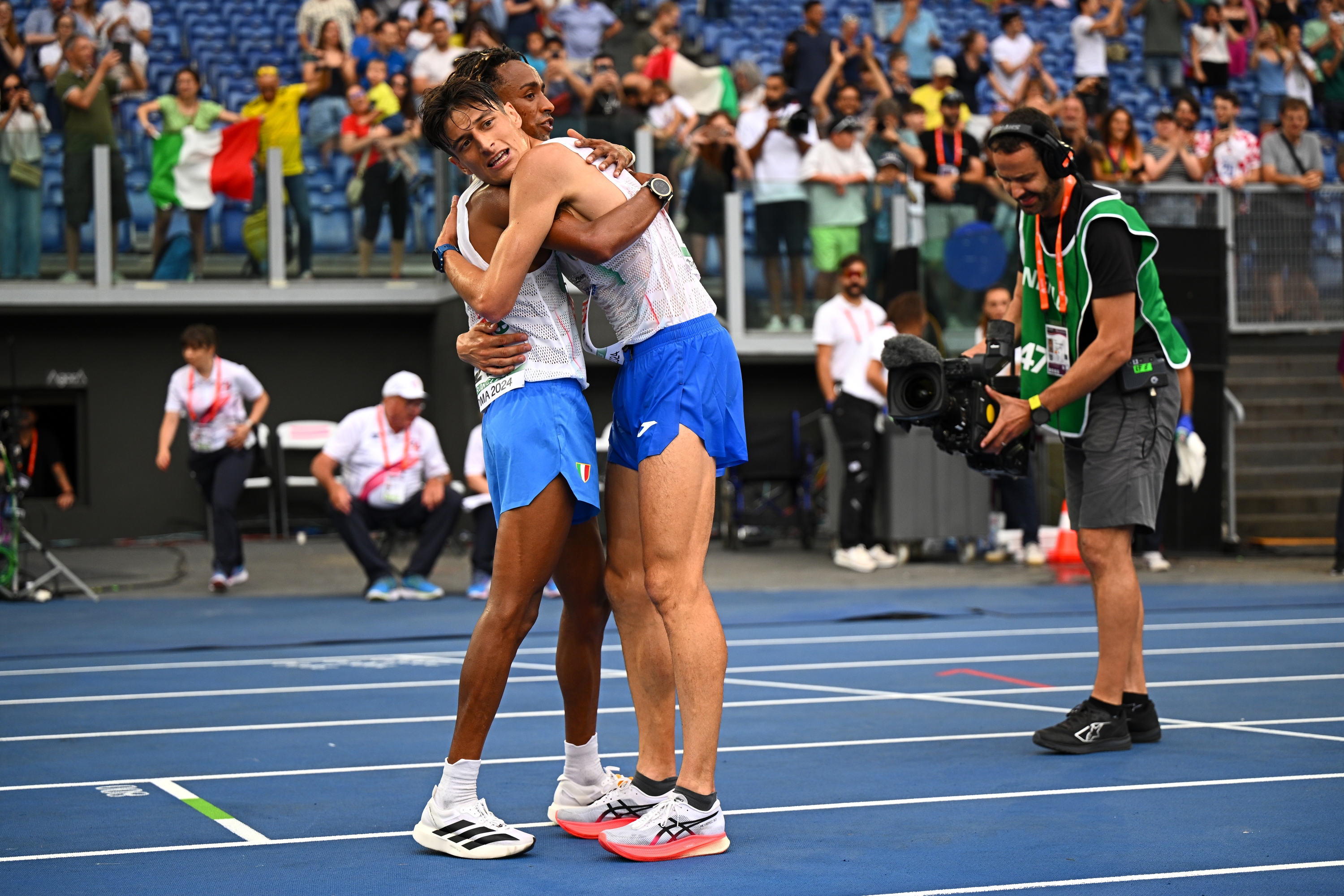 ROME, ITALY - JUNE 09: Gold medalist, Yemaneberhan Crippa and silver medallist, Pietro Riva of Team Italy embrace following the Men's Half Marathon Final on day three of the 26th European Athletics Championships - Rome 2024 at Stadio Olimpico on June 09, 2024 in Rome, Italy. (Photo by Mattia Ozbot/Getty Images for European Athletics)