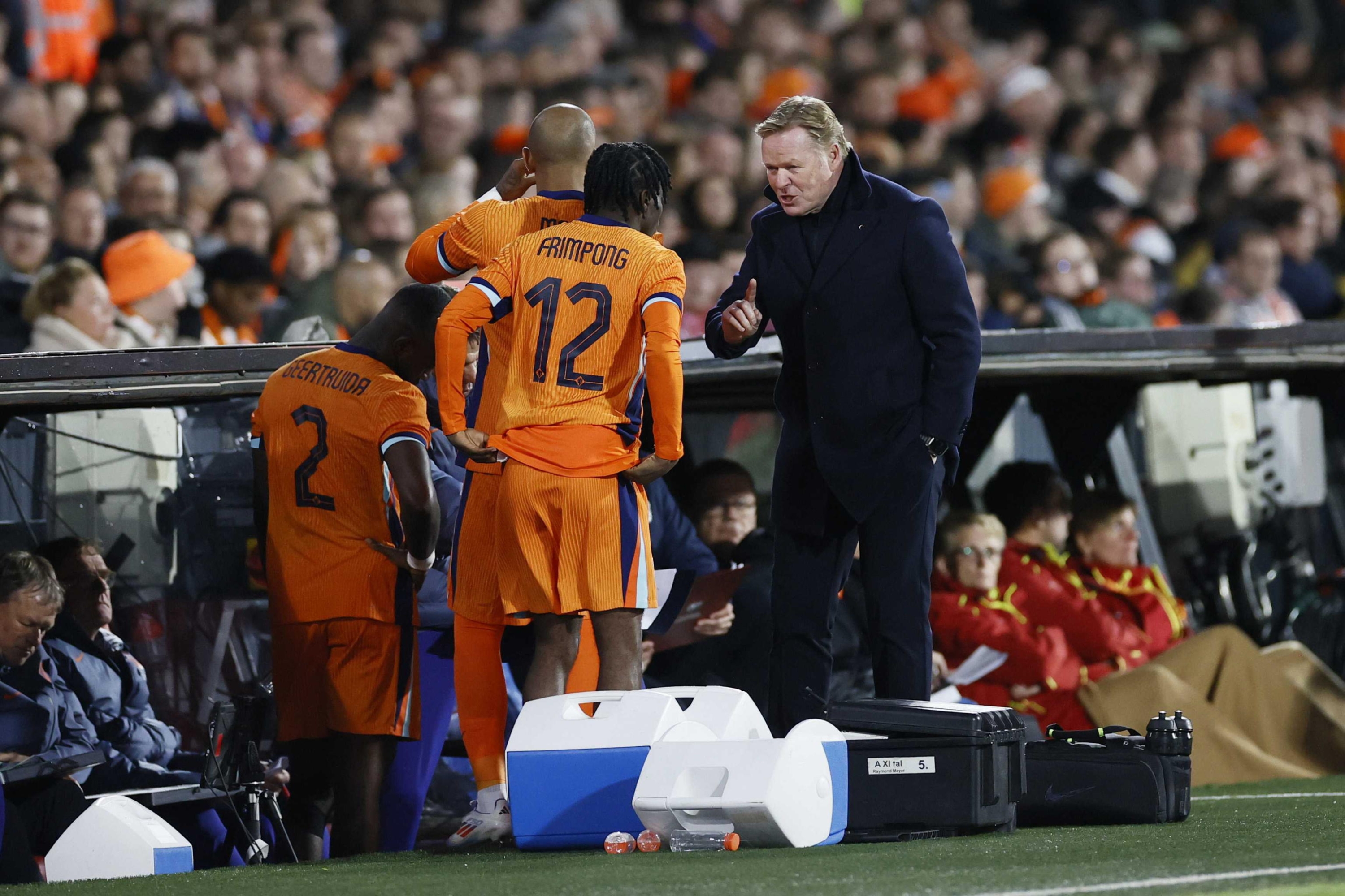 epa11402978 Head coach Ronald Koeman of the Netherlands speaks with his players Lutsharel Geertruida and Jeremie Frimpong (C) during the friendly international soccer match between the Netherlands and Iceland in Rotterdam, the Netherlands, 10 June 2024.  EPA/PIETER STAM DE JONGE