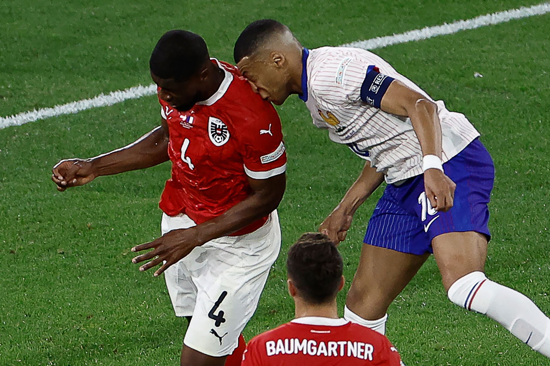 TOPSHOT - France's forward #10 Kylian Mbappe collides with Austria's defender #04 Kevin Danso during the UEFA Euro 2024 Group D football match between Austria and France at the Duesseldorf Arena in Duesseldorf on June 17, 2024. (Photo by KENZO TRIBOUILLARD / AFP)
