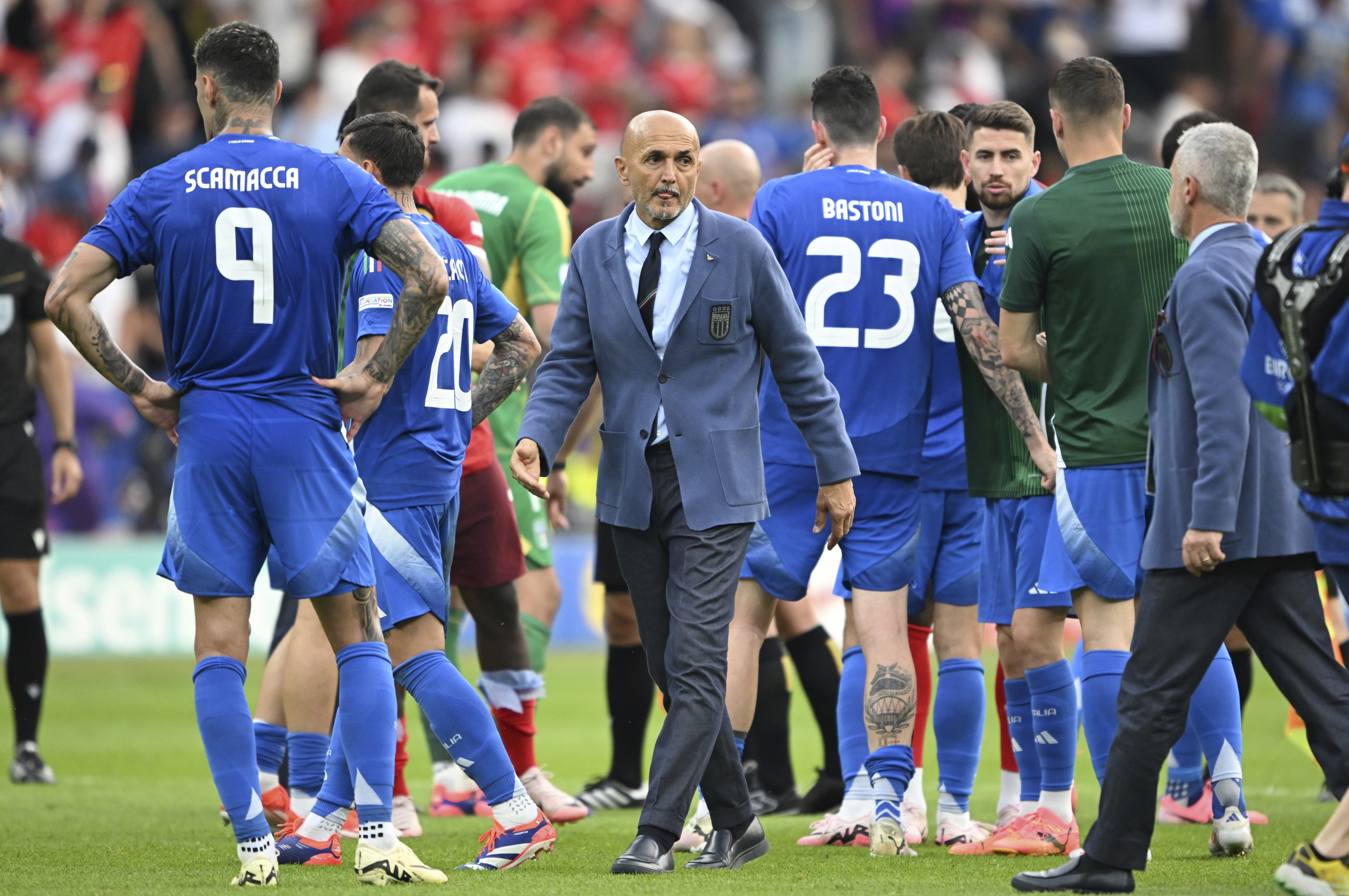 Italy's coach Luciano Spalletti, center, walks between his players after a round of sixteen match between Switzerland and Italy at the Euro 2024 soccer tournament in Berlin, Germany, Saturday, June 29, 2024. (Robert Michael/dpa via AP)