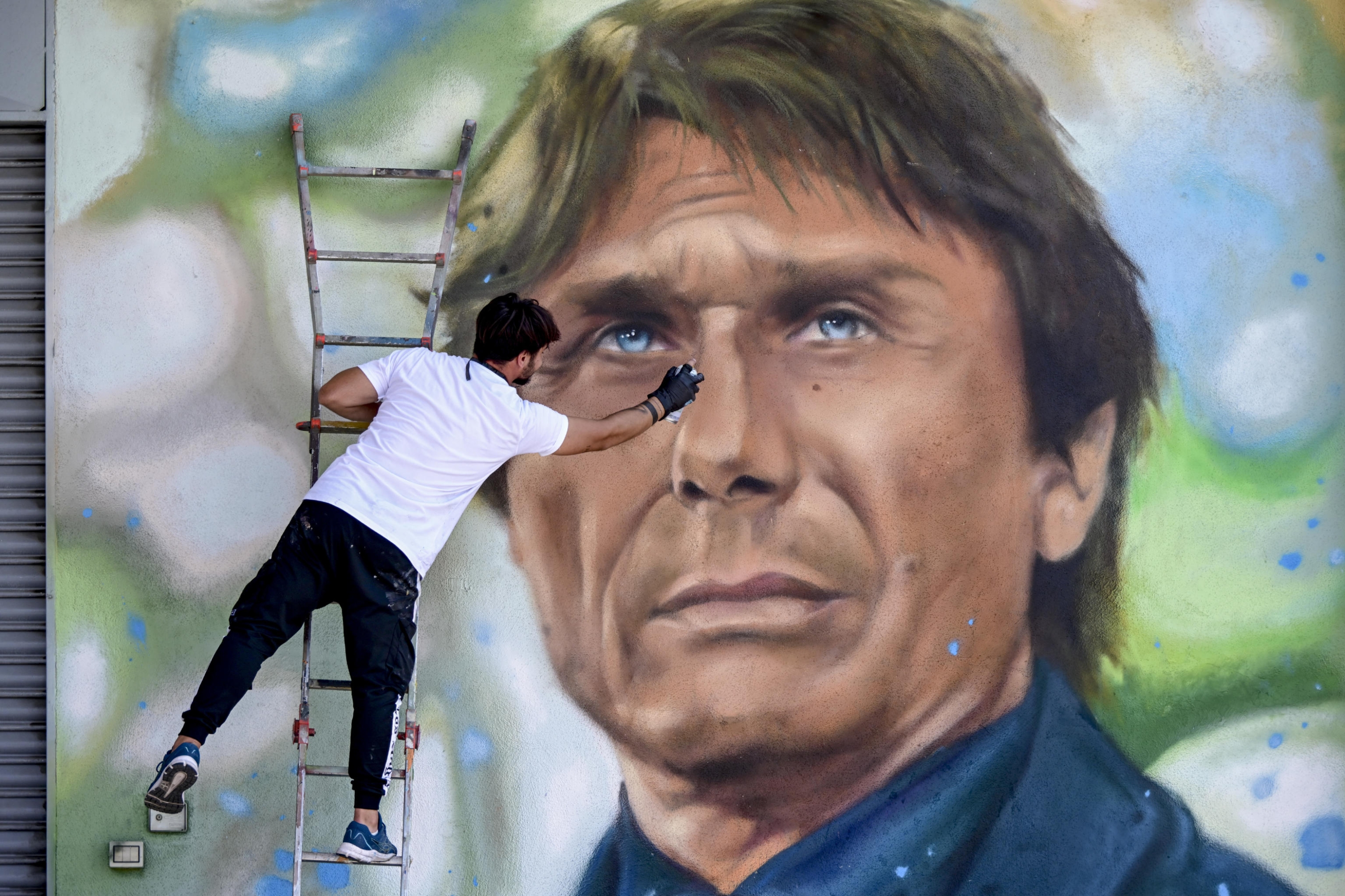 Il grande murale con il ritratto del nuovo allenatore del Napoli Antonio Conte realizzato dal writer Luciano Ranieri , 29  giugno 2024.   The street artist Luciano Ranieri creating a large mural with the portrait of the new Napoli coach Antonio County Naples, Italy, 29 June 2024. Five meters by four are the dimensions of the work commissioned to Ranieri by an entrepreneur of proven Azzurri faith as soon as the certainty of the hiring of the former Juve and Chelsea coach became widespread in the city. ANSA / Ciro Fusco