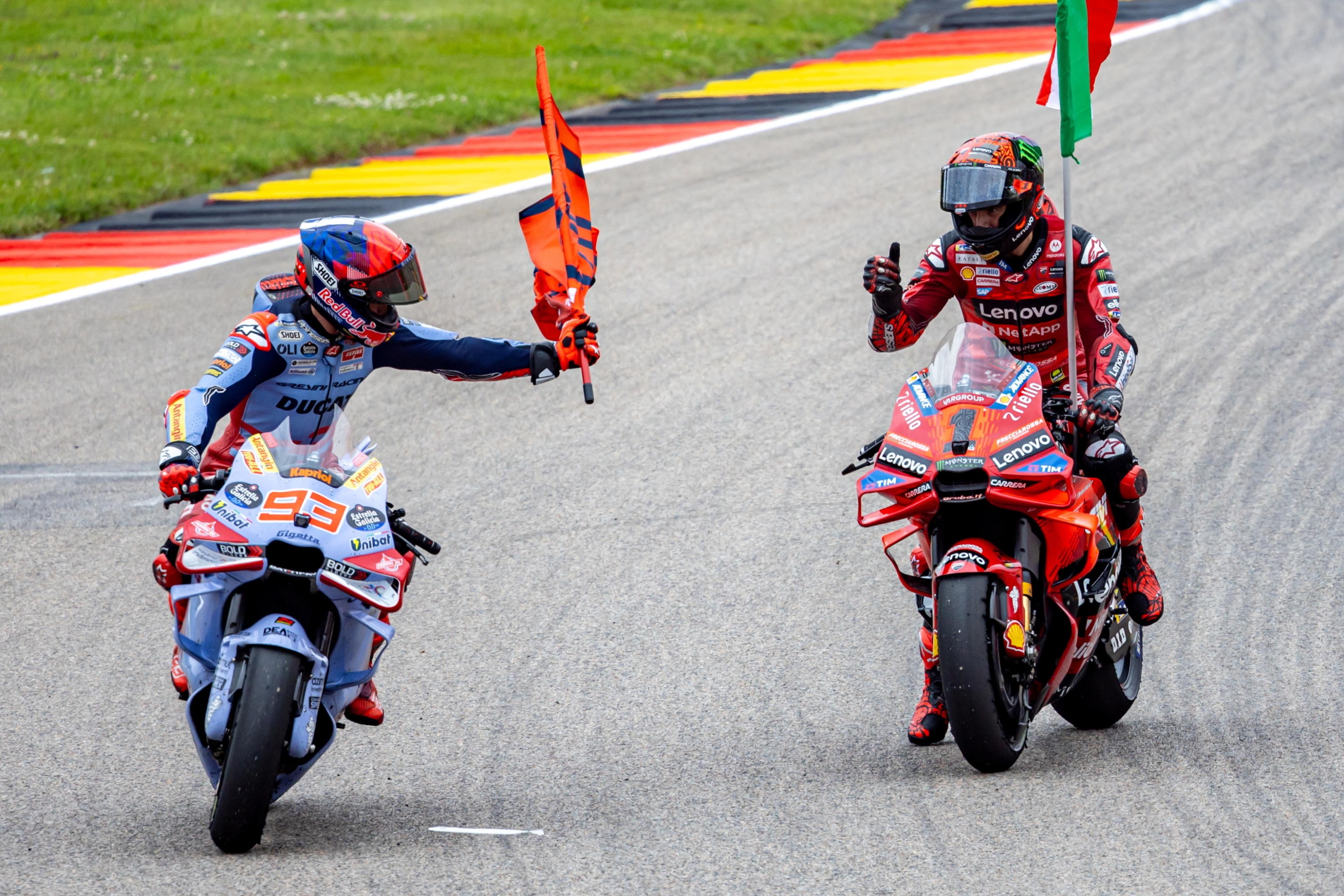 epa11464939 Ducati Lenovo rider Francesco Bagnaia of Italy (R) celebrates with second placed Gresini Racing rider Marc Marquez of Spain (L) after winning the MotoGP race of the Motorcycling Grand Prix of Germany, at the Sachsenring racetrack in Hohenstein-Ernstthal, Germany, 07 July 2024.  EPA/MARTIN DIVISEK
