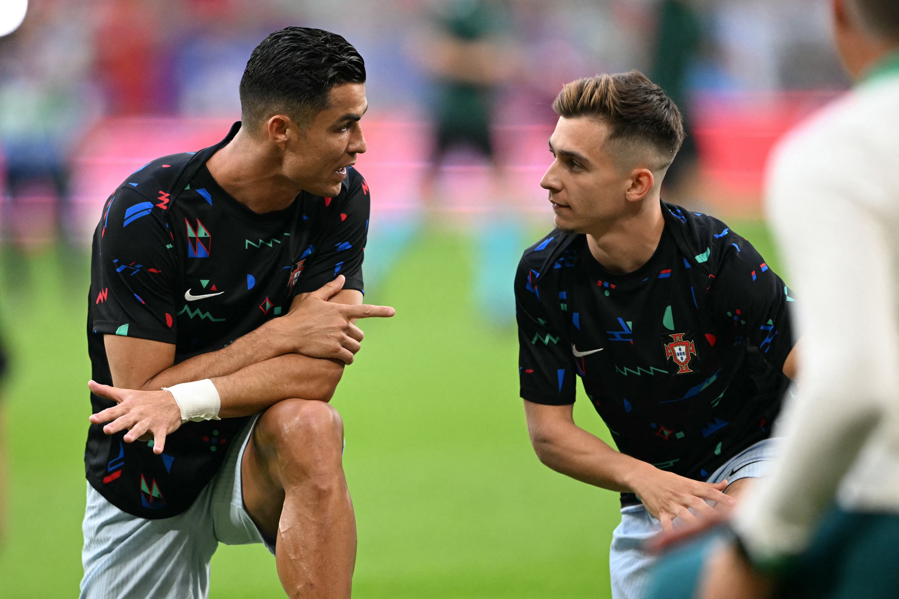 Portugal's forward #07 Cristiano Ronaldo and Portugal's forward #26 Francisco Conceicao talk as they warm up prior to the UEFA Euro 2024 Group F football match between Georgia and Portugal at the Arena AufSchalke in Gelsenkirchen on June 26, 2024. (Photo by OZAN KOSE / AFP)