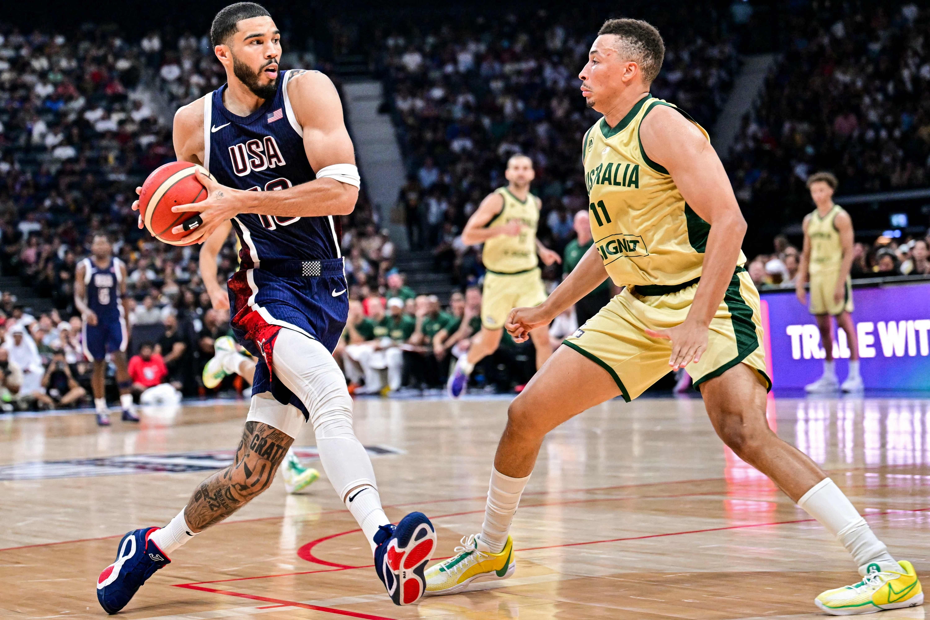 Australia's guard #11 Dante Exum marks USA's forward #10 Jayson Tatum during the Basketball Showcase friendly match between the United States and Australia at Etihad Arena in Abu Dhabi on July 15, 2024. (Photo by Giuseppe CACACE / AFP)
