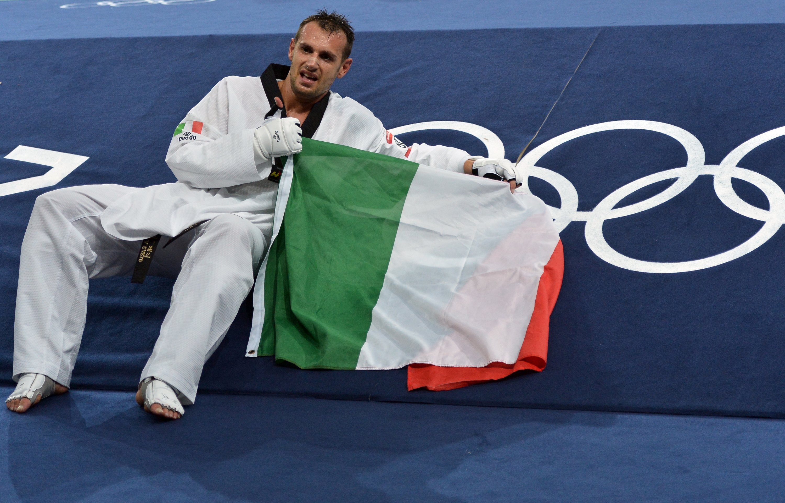 Italy's Carlo Molfetta celebrates his victory over Gabon's Anthony Obame at the end of their men's taekwondo gold medal bout in the + 80 kg category as part of the London 2012 Olympic games, on August 11, 2012 at the ExCel centre in London. AFP PHOTO / ALBERTO PIZZOLI (Photo by ALBERTO PIZZOLI / AFP)