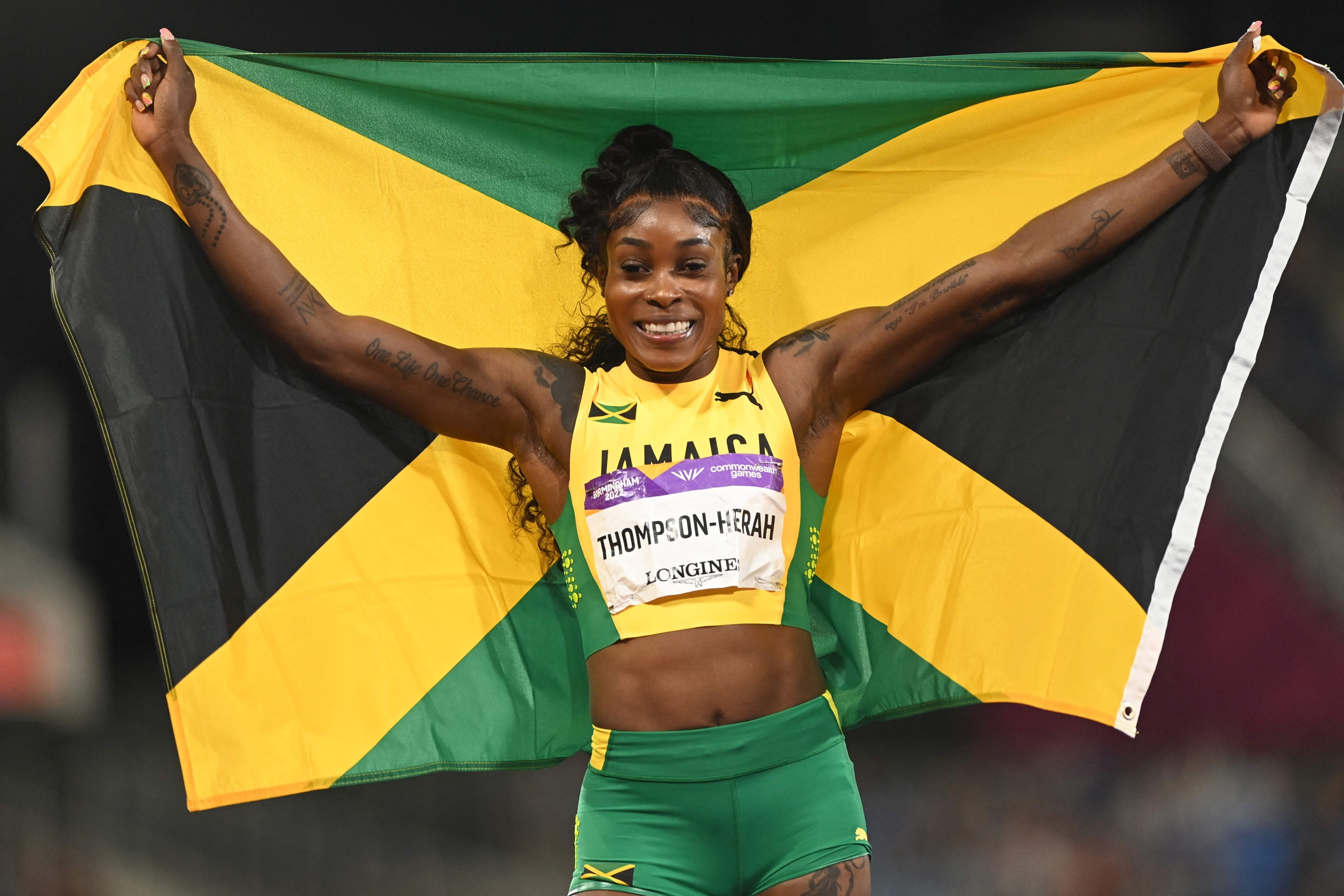 (FILES) Jamaica's Elaine Thompson-Herah celebrates winning and taking the gold medal, and set a new Commonwealth record in the women's 200m final athletics event at the Alexander Stadium, on day nine of the Commonwealth Games in Birmingham, central England, on August 6, 2022. Hard blow for the Jamaican sprint one month before the Paris Olympic Games. Double Olympic 100m and 200m champion Elaine Thompson-Herah will not defend her titles in Paris this summer due to an Achilles tendon injury. (Photo by Glyn KIRK / AFP)
