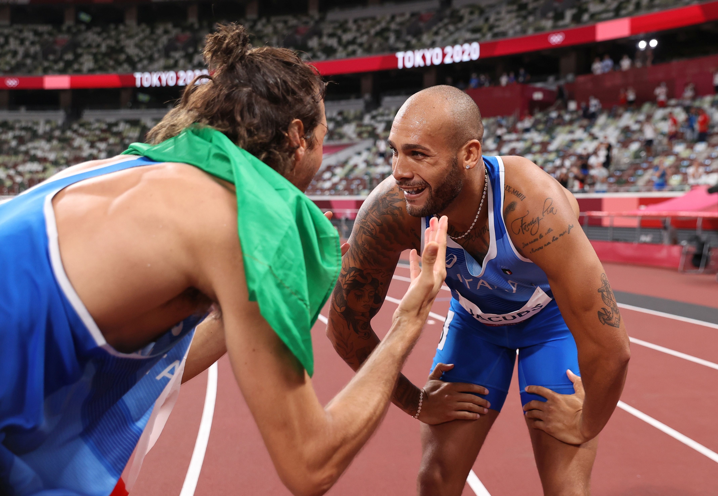 TOKYO, JAPAN - AUGUST 01: Lamont Marcell Jacobs of Team Italy is congratulated by teammate Gianmarco Tamberi after winning the Men's 100m Final on day nine of the Tokyo 2020 Olympic Games at Olympic Stadium on August 01, 2021 in Tokyo, Japan. (Photo by Cameron Spencer/Getty Images)