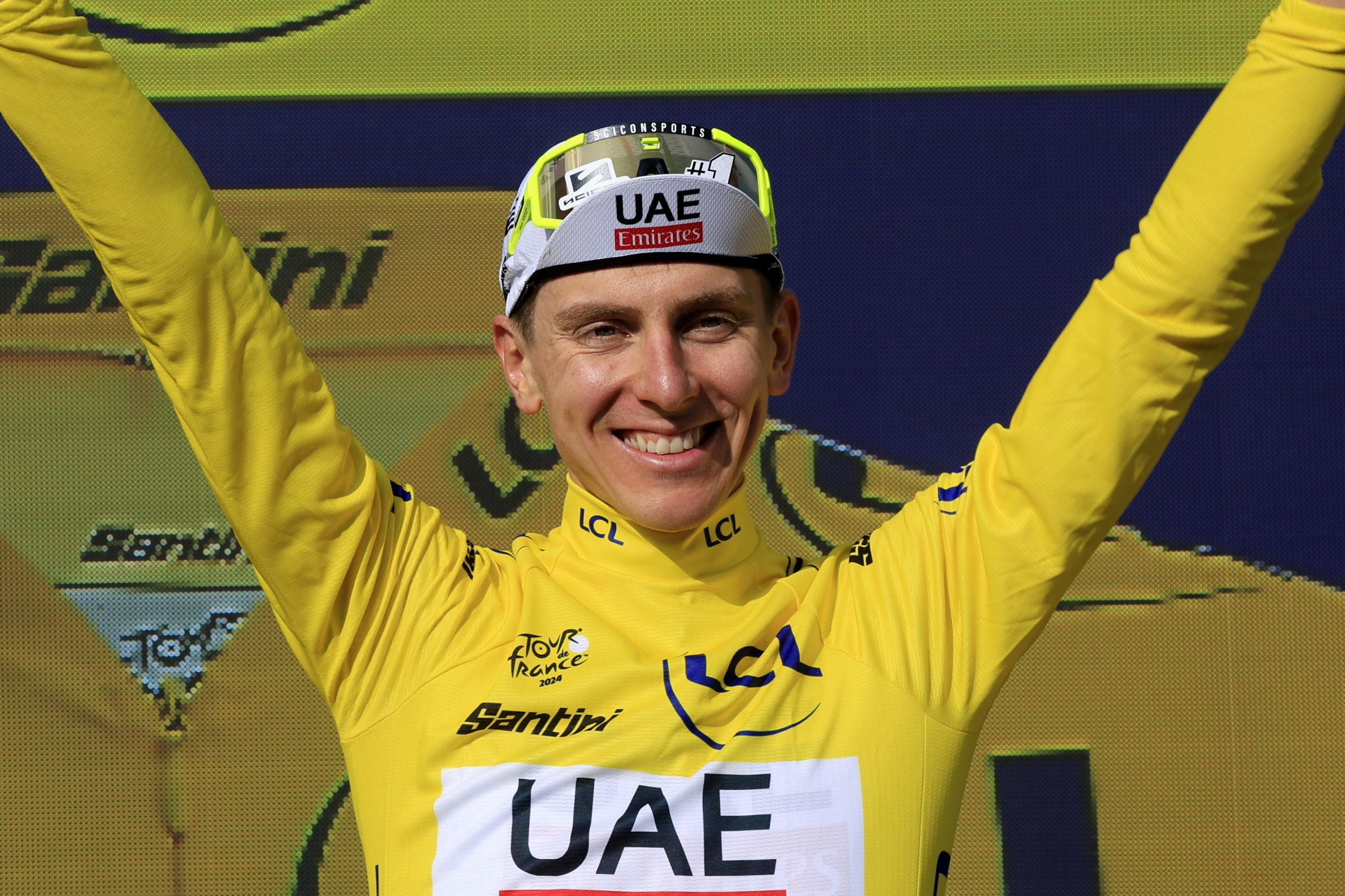 epa11489481 Slovenian rider Tadej Pogacar of UAE Team Emirates celebrates in the overall leader's yellow jersey on the podium after winning the 20th stage of the 2024 Tour de France cycling race over 132km from Nice to Col de la Couillole, France, 20 July 2024.  EPA/GUILLAUME HORCAJUELO