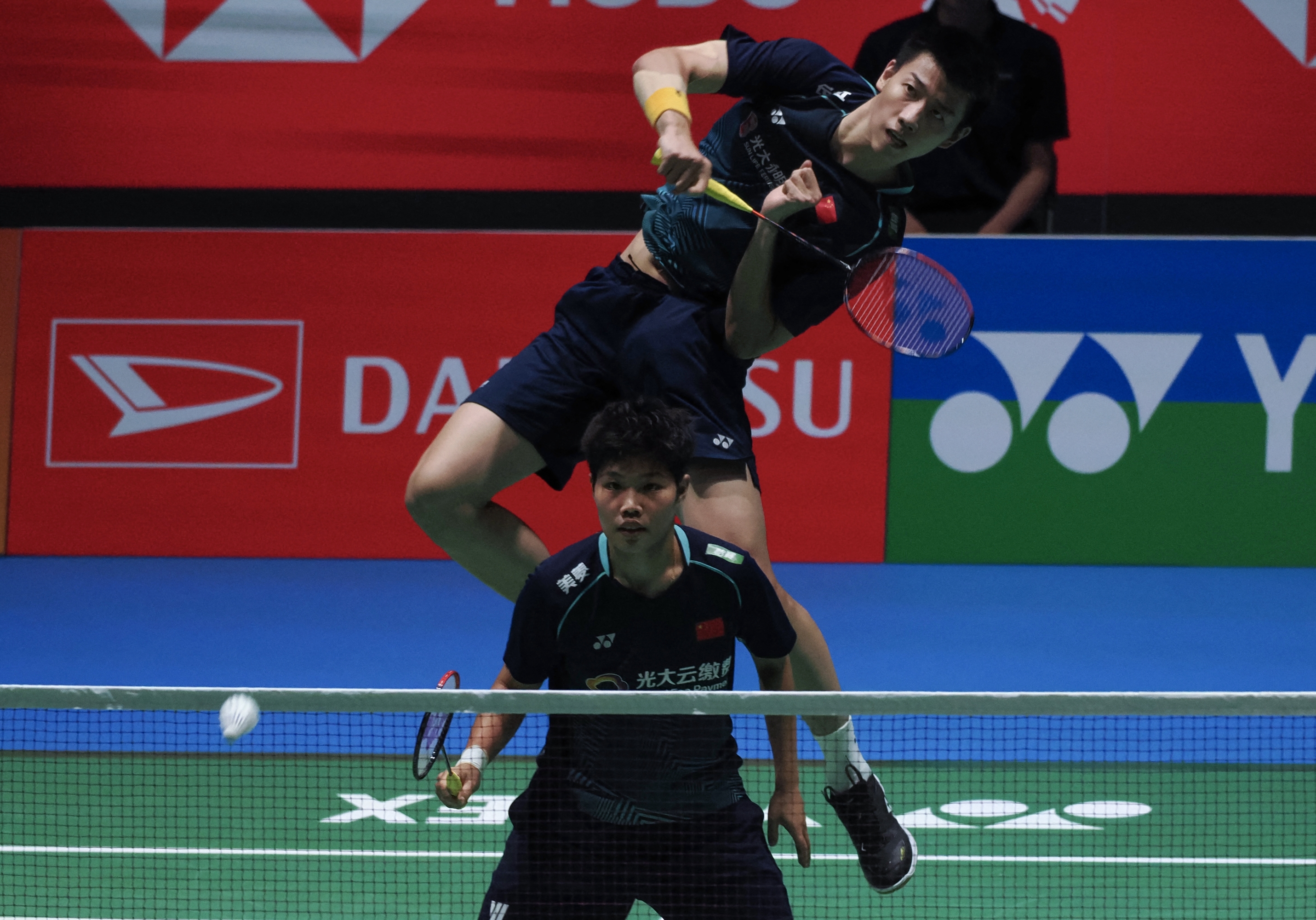 Feng Yan Zhe (rear) and Huang Dong Ping of China hits a return against Dechapol Puavaranukroh and Sapsiree Taerattanachai of Thailand (not pictured) during their mixed double semi final match on the fifth day of the Japan Open badminton tournament in Tokyo on July 29, 2023. (Photo by Toshifumi KITAMURA / AFP)