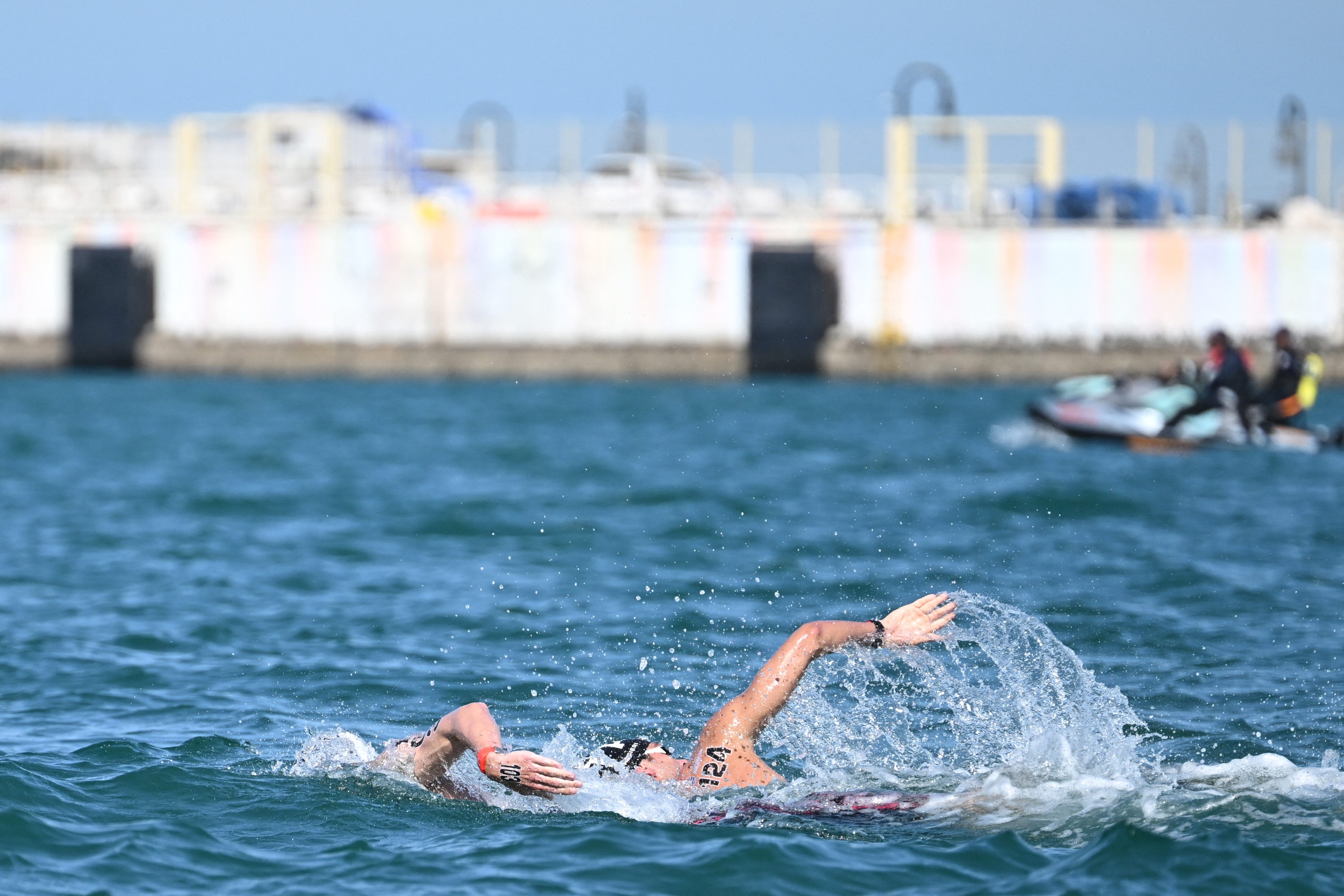 Germany's Florian Wellbrock and Italy's Gregorio Paltrinieri compete in the final of the men's 5km open water swimming event during the 2024 World Aquatics Championships at Doha Port in Doha on February 7, 2024. (Photo by Manan VATSYAYANA / AFP)