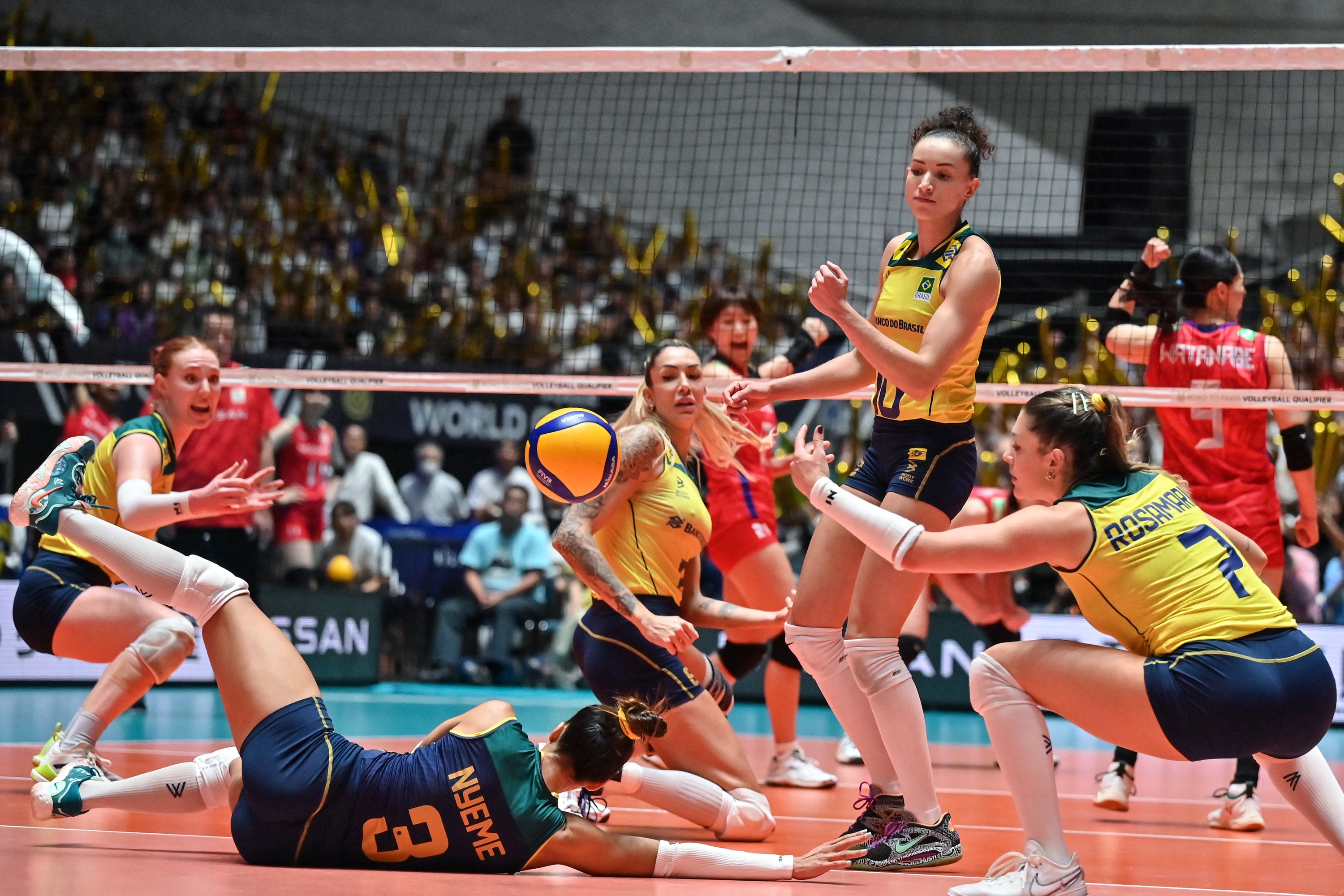 Brazil's Victoria Alexandre Costa Nunes Nyeme (bottom L-#3) dives to attempt a return during the match on the final day of the Volleyball World Cup 2023 women's Olympic qualifying tournament between Japan and Brazil at Yoyogi National Stadium in Tokyo on September 24, 2023. (Photo by Richard A. Brooks / AFP)