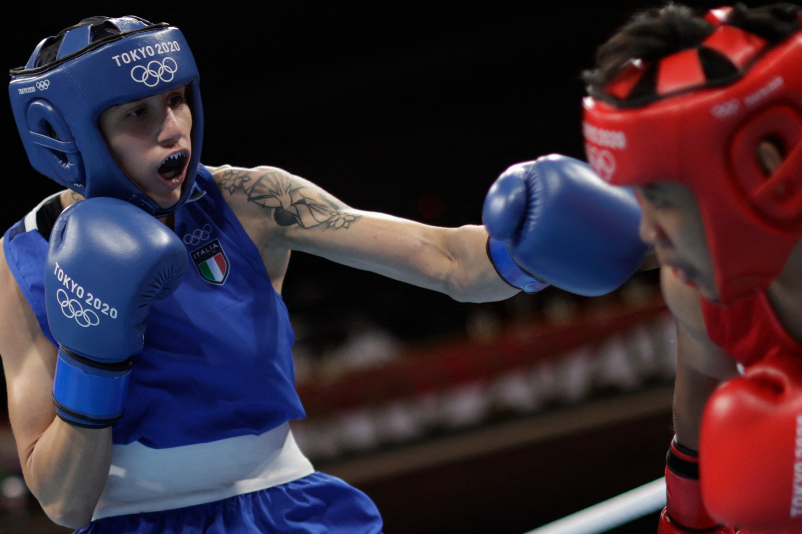 Philippines' Nesthy Petecio (red) and Italy's Irma Testa fight during their women's feather (54-57kg) semi-final boxing match during the Tokyo 2020 Olympic Games at the Kokugikan Arena in Tokyo on July 31, 2021. (Photo by UESLEI MARCELINO / POOL / AFP)
