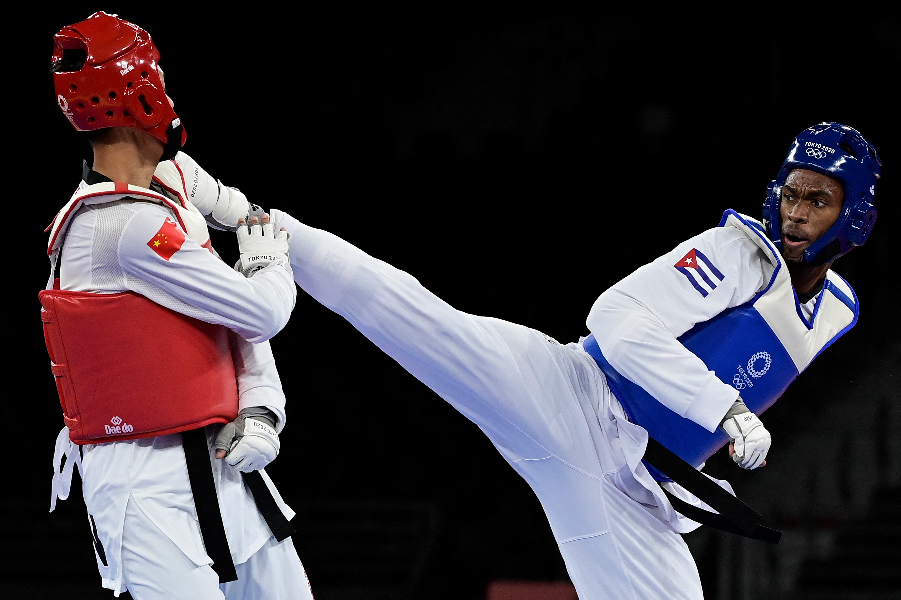 Cuba's Rafael Yunier Alba Castillo (Blue) and China's Sun Hongyi (Red) compete in the taekwondo men's +80kg bronze medal B bout during the Tokyo 2020 Olympic Games at the Makuhari Messe Hall in Tokyo on July 27, 2021. (Photo by Javier SORIANO / AFP)