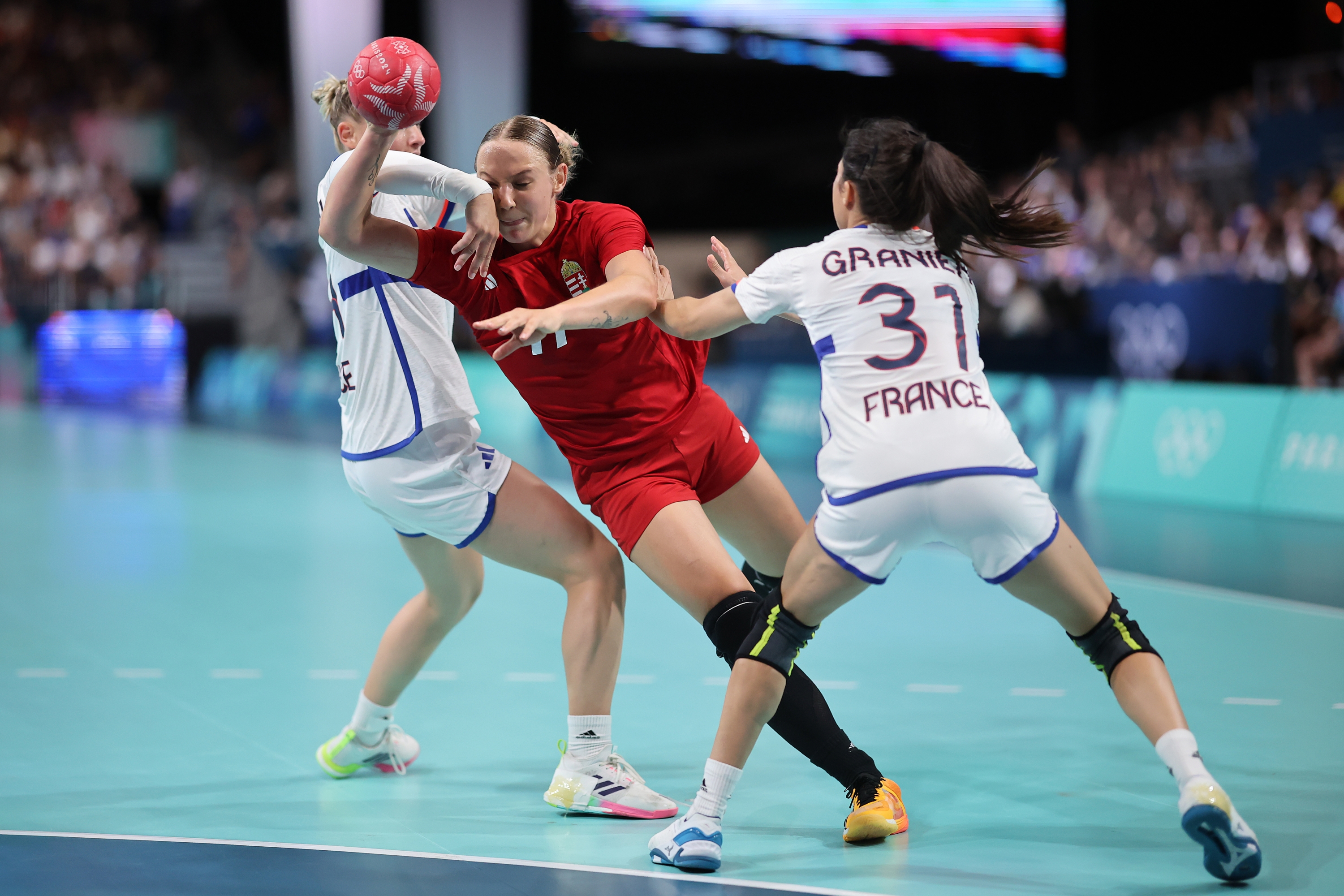 PARIS, FRANCE - JULY 25: Petra Simon #77 of Team Hungary shoots at the goal past Lucie Granier #3 of Team France during the Women's Handball Group B match between Hungary and France on Day -1 of the Olympic Games Paris 2024 at South Paris Arena on July 25, 2024 in Paris, France. (Photo by Hector Vivas/Getty Images)
