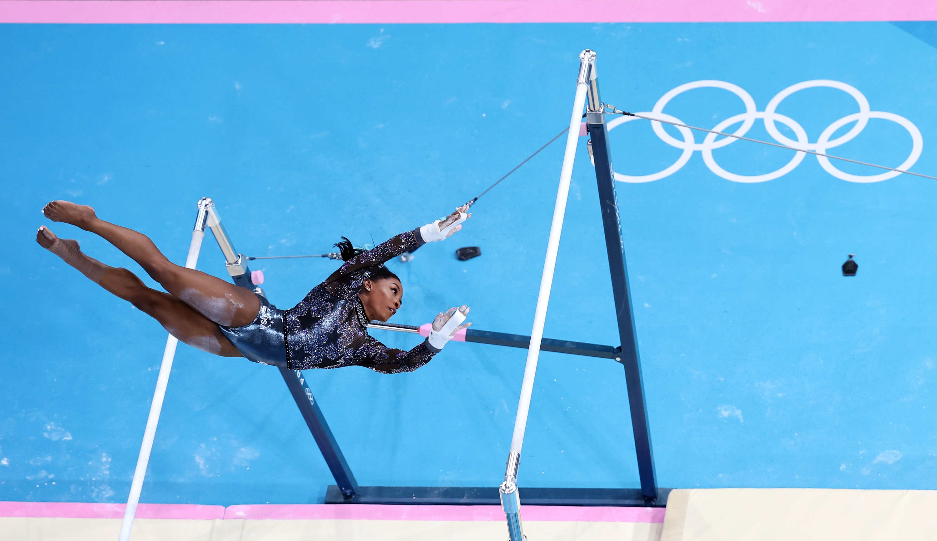 PARIS, FRANCE - JULY 28: (EDITORS NOTE: Image was captured using a remote camera positioned above the field of play) Simone Biles of Team United States competes on the uneven bars during the Artistic Gymnastics Women's Qualification on day two of the Olympic Games Paris 2024 at Bercy Arena on July 28, 2024 in Paris, France. (Photo by Dan Mullan/Getty Images)