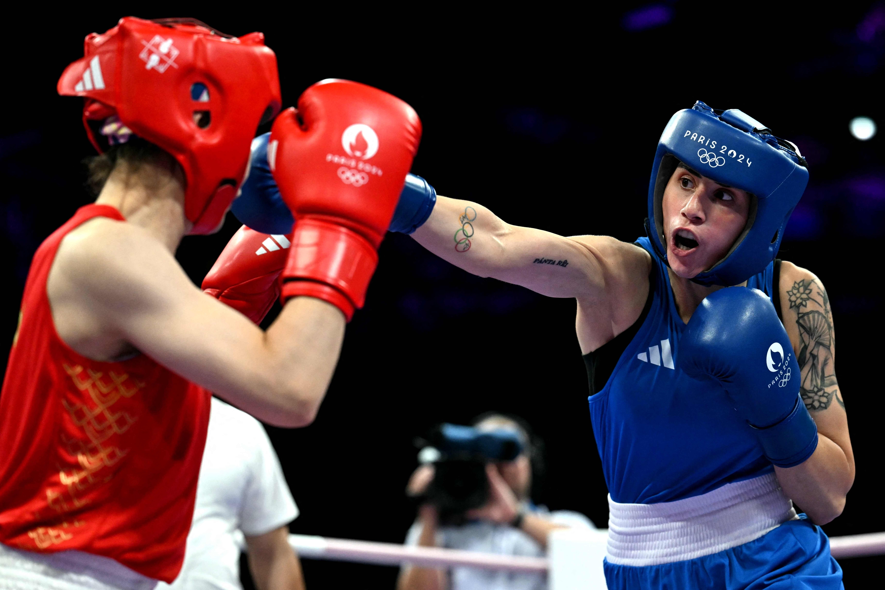 Italy's Irma Testa (in blue) punches China's Zichun Xu in the women's 57kg preliminaries round of 32 boxing match during the Paris 2024 Olympic Games at the North Paris Arena, in Villepinte on July 30, 2024. (Photo by MOHD RASFAN / AFP)