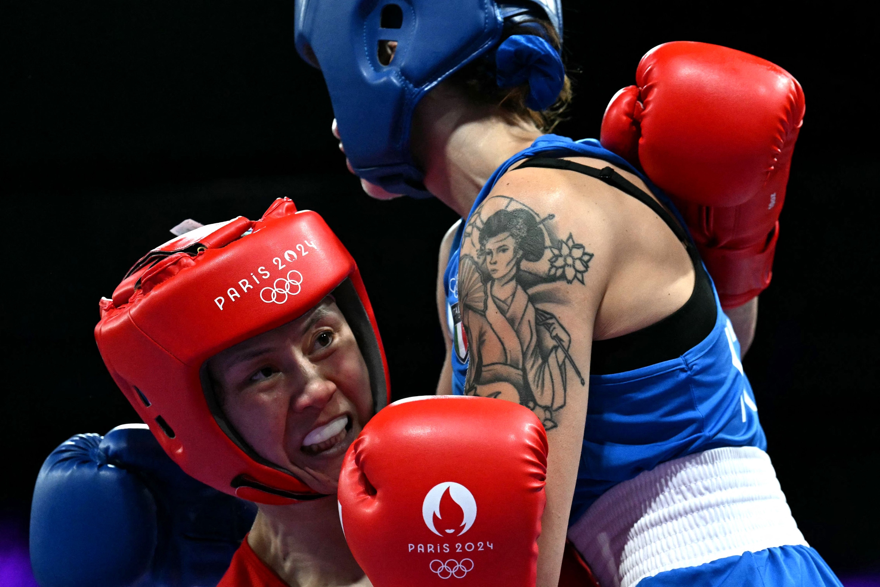 Italy's Irma Testa (in blue) fights against China's Zichun Xu in the women's 57kg preliminaries round of 32 boxing match during the Paris 2024 Olympic Games at the North Paris Arena, in Villepinte on July 30, 2024. (Photo by MOHD RASFAN / AFP)
