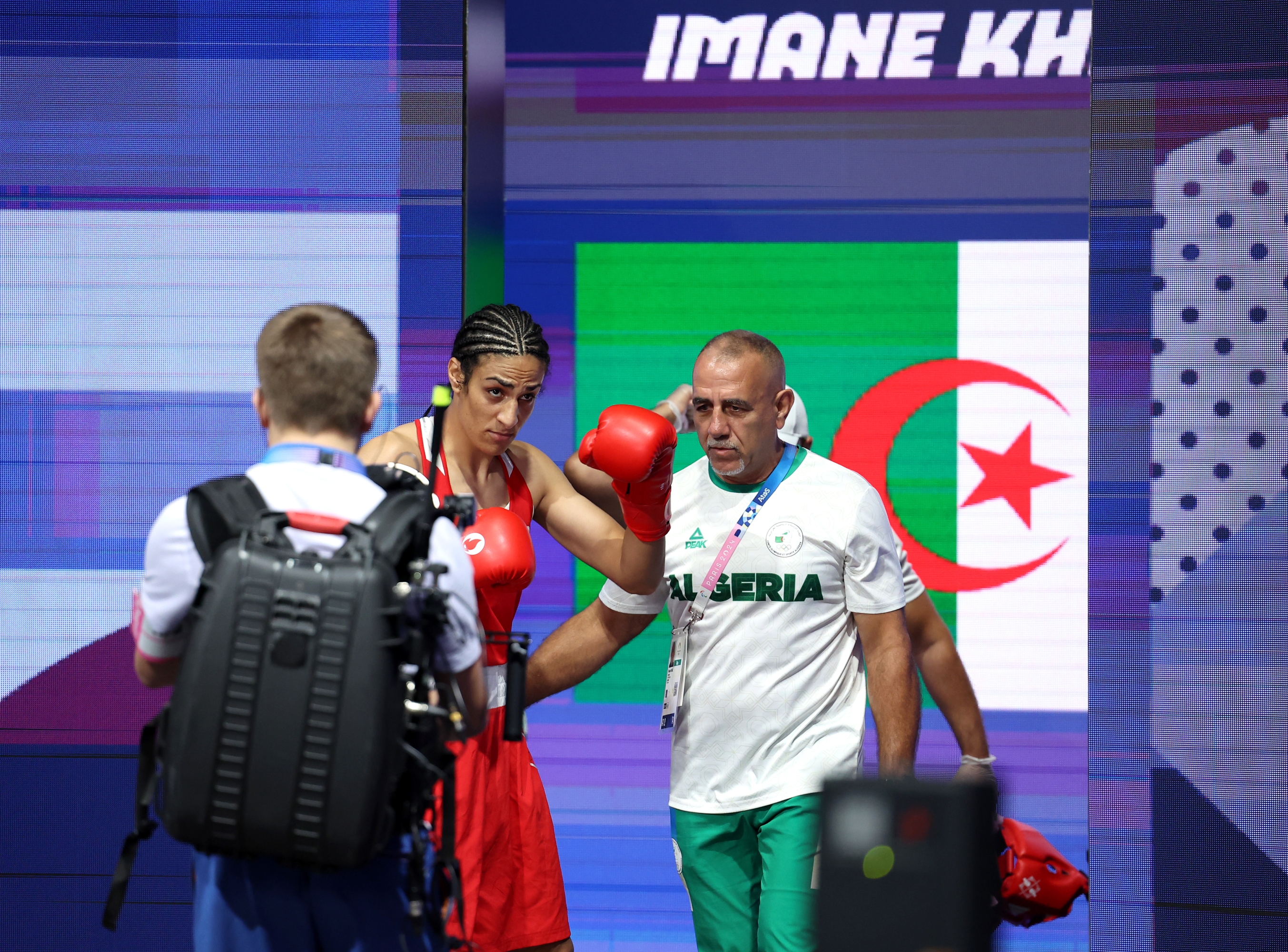 PARIS, FRANCE - AUGUST 01: Imane Khelif of Team Algeria makes her way to the ring with Team Algeria Coach Pedro Diaz prior to the Women's 66kg preliminary round match against Angela Carini of Team Italy on day six of the Olympic Games Paris 2024 at North Paris Arena on August 01, 2024 in Paris, France. (Photo by Richard Pelham/Getty Images) *** BESTPIX ***