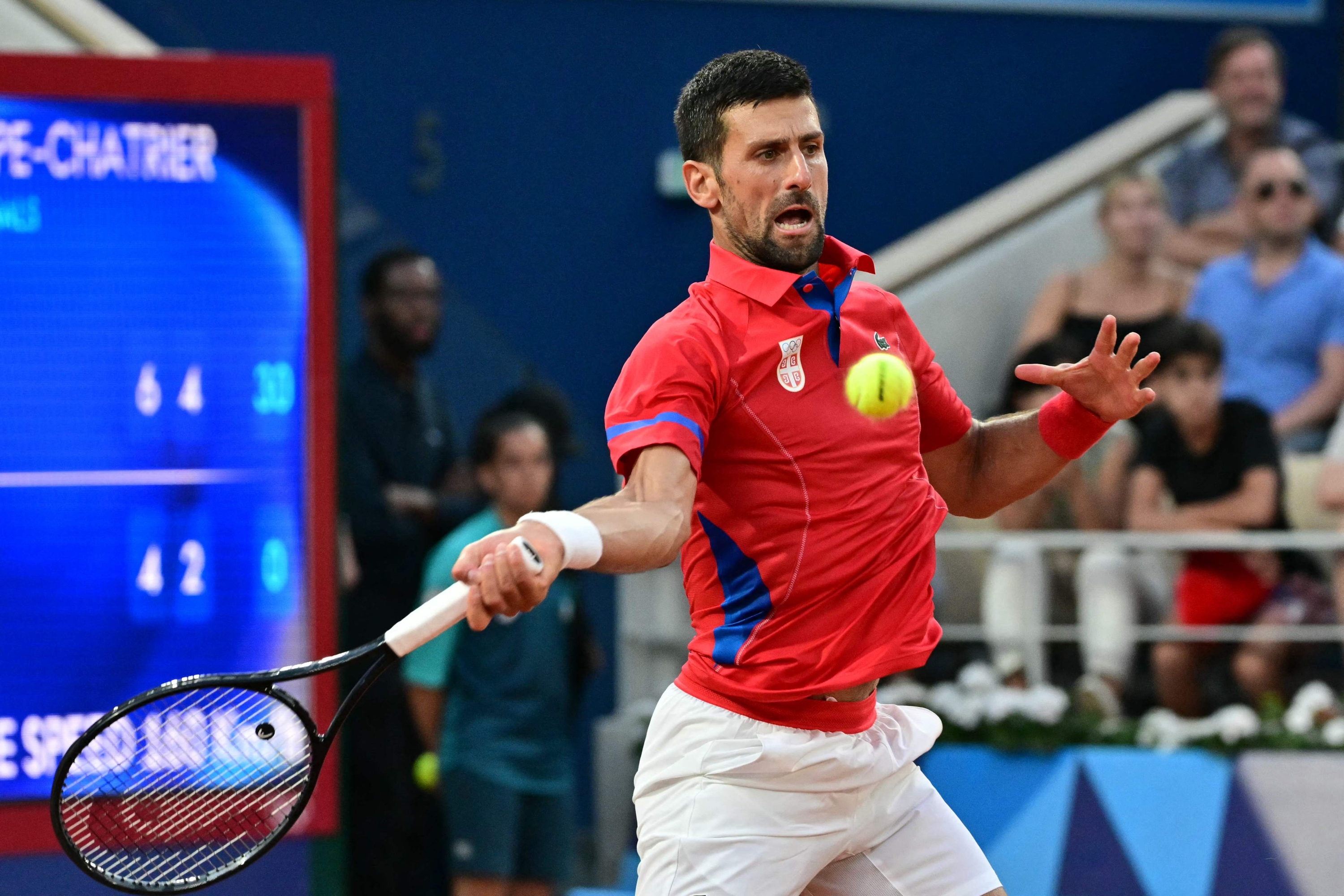 Serbia's Novak Djokovic returns to Italy's Lorenzo Musetti during their men's singles semi-final tennis match on Court Philippe-Chatrier at the Roland-Garros Stadium during the Paris 2024 Olympic Games, in Paris on August 2, 2024. (Photo by Miguel MEDINA / AFP)