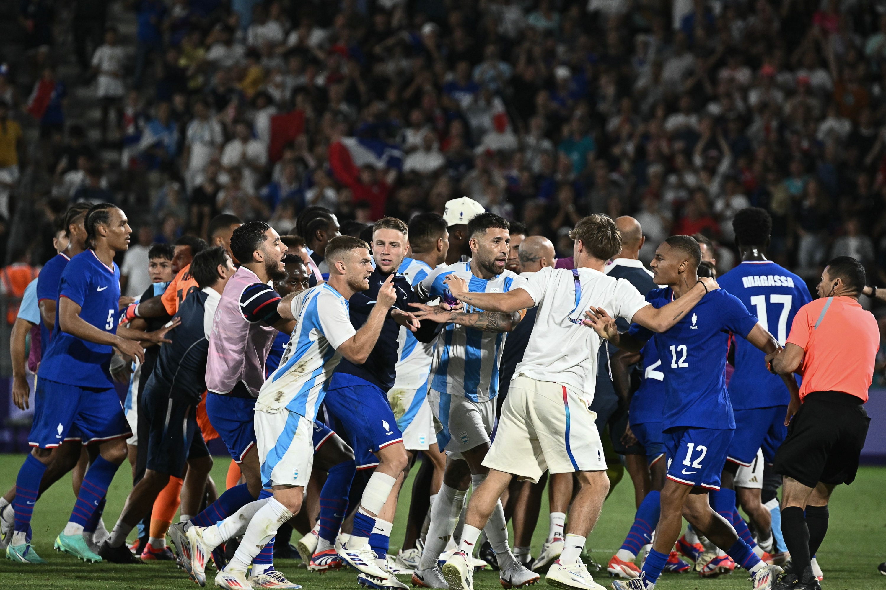 TOPSHOT - France's and Argentina's team react after France won in the men's quarter-final football match between France and Argentina during the Paris 2024 Olympic Games at the Bordeaux Stadium in Bordeaux on August 2, 2024. (Photo by Philippe LOPEZ / AFP)