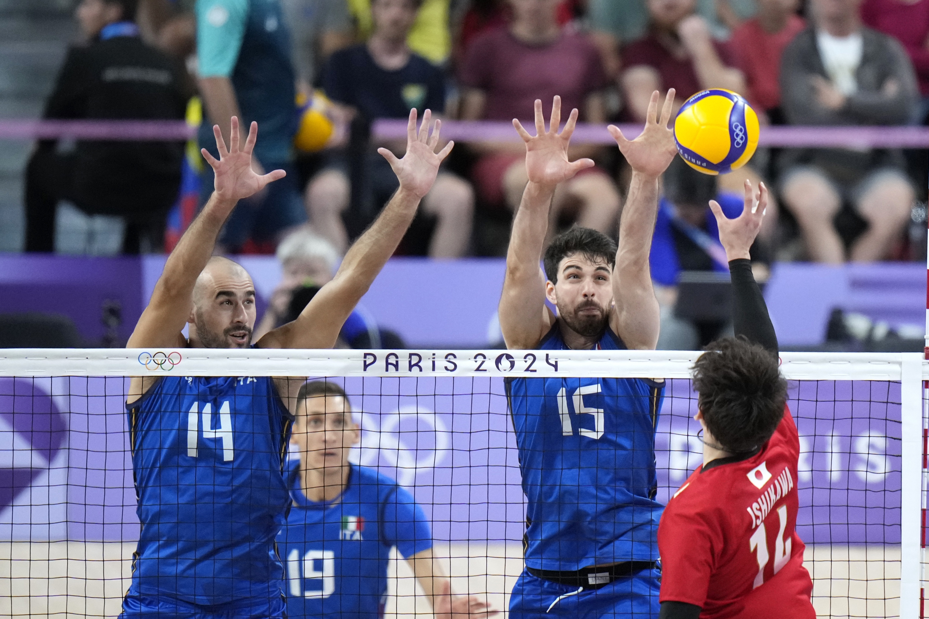 Gianluca Galassi, left, and Daniele Lavia, of Italy, block a ball by Yuki Ishikawa, of Japan, during a men's quarter final volleyball match between Italy and Japan at the 2024 Summer Olympics, Monday, Aug. 5, 2024, in Paris, France. (AP Photo/Alessandra Tarantino)