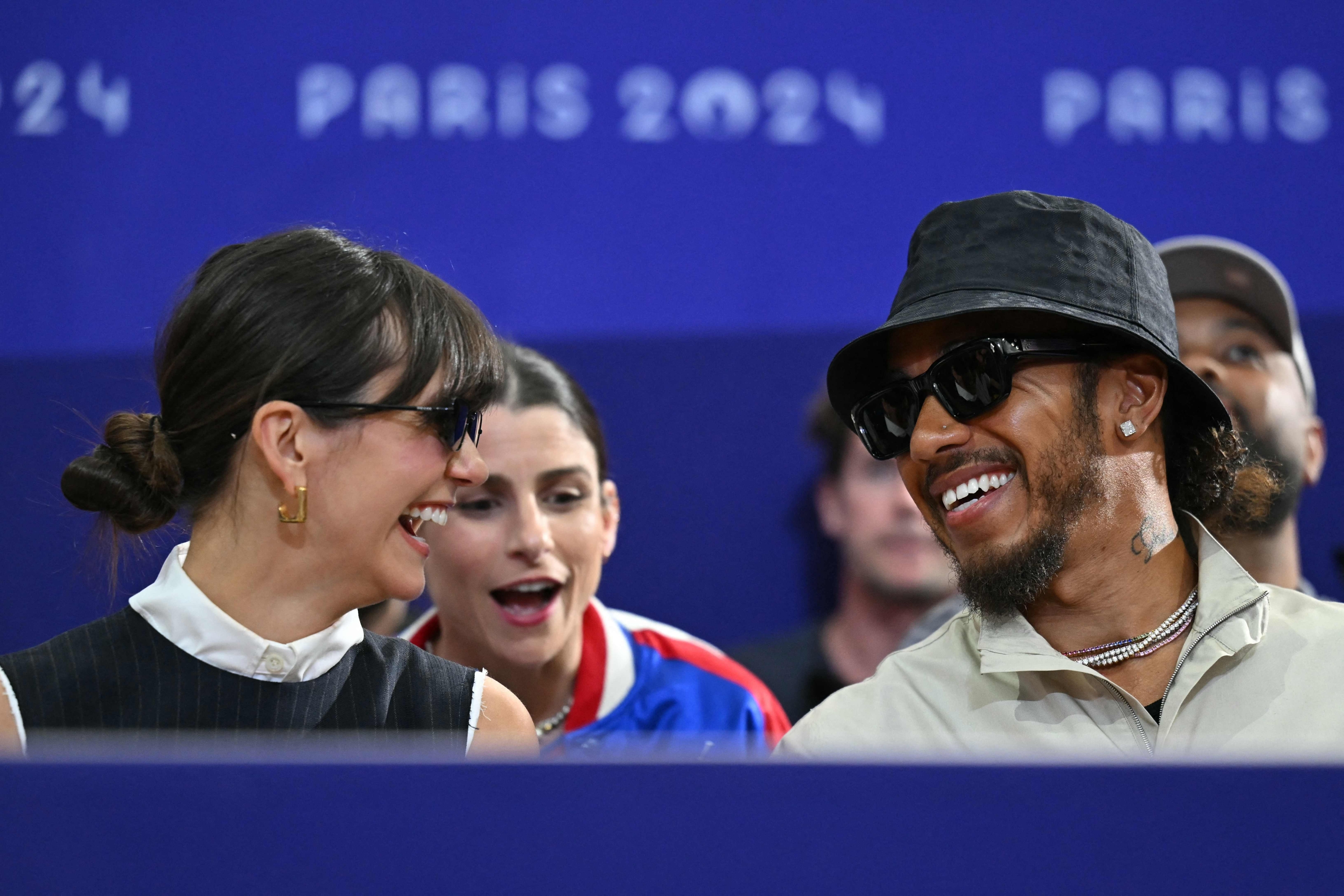 Canadian model Nina Dobrev (L) and Mercedes' British F1 driver Lewis Hamilton attend the men's foil team bronze medal bout between USA and France during the Paris 2024 Olympic Games at the Grand Palais in Paris, on August 4, 2024. (Photo by Fabrice COFFRINI / AFP)