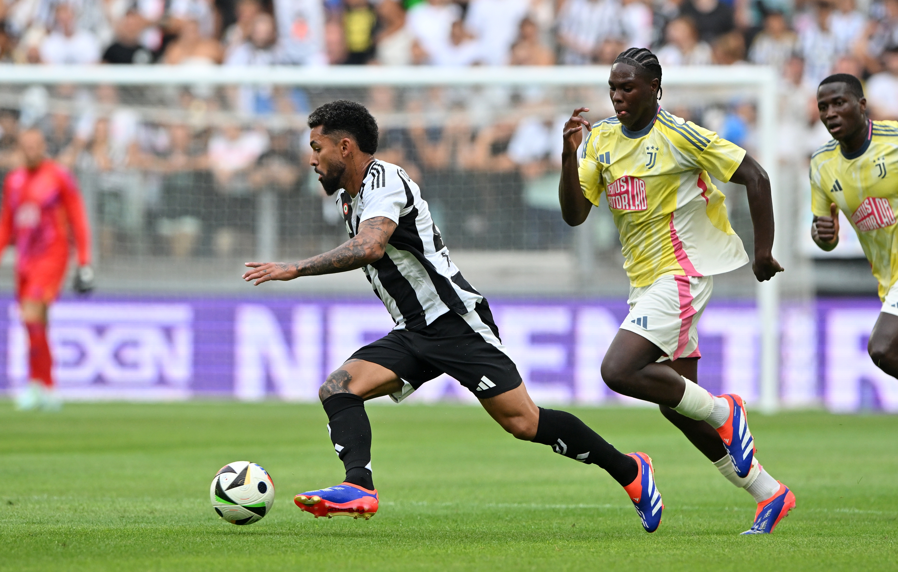 TURIN, ITALY - AUGUST 6: Douglas Luiz of Juventus evades a challenge from Augusto Owusu of Juventus Next Gen during the Pre-season Friendly between Juventus and Juventus Next Gen at Allianz Stadium on August 6, 2024 in Turin, Italy. (Photo by Chris Ricco - Juventus FC/Juventus FC via Getty Images)