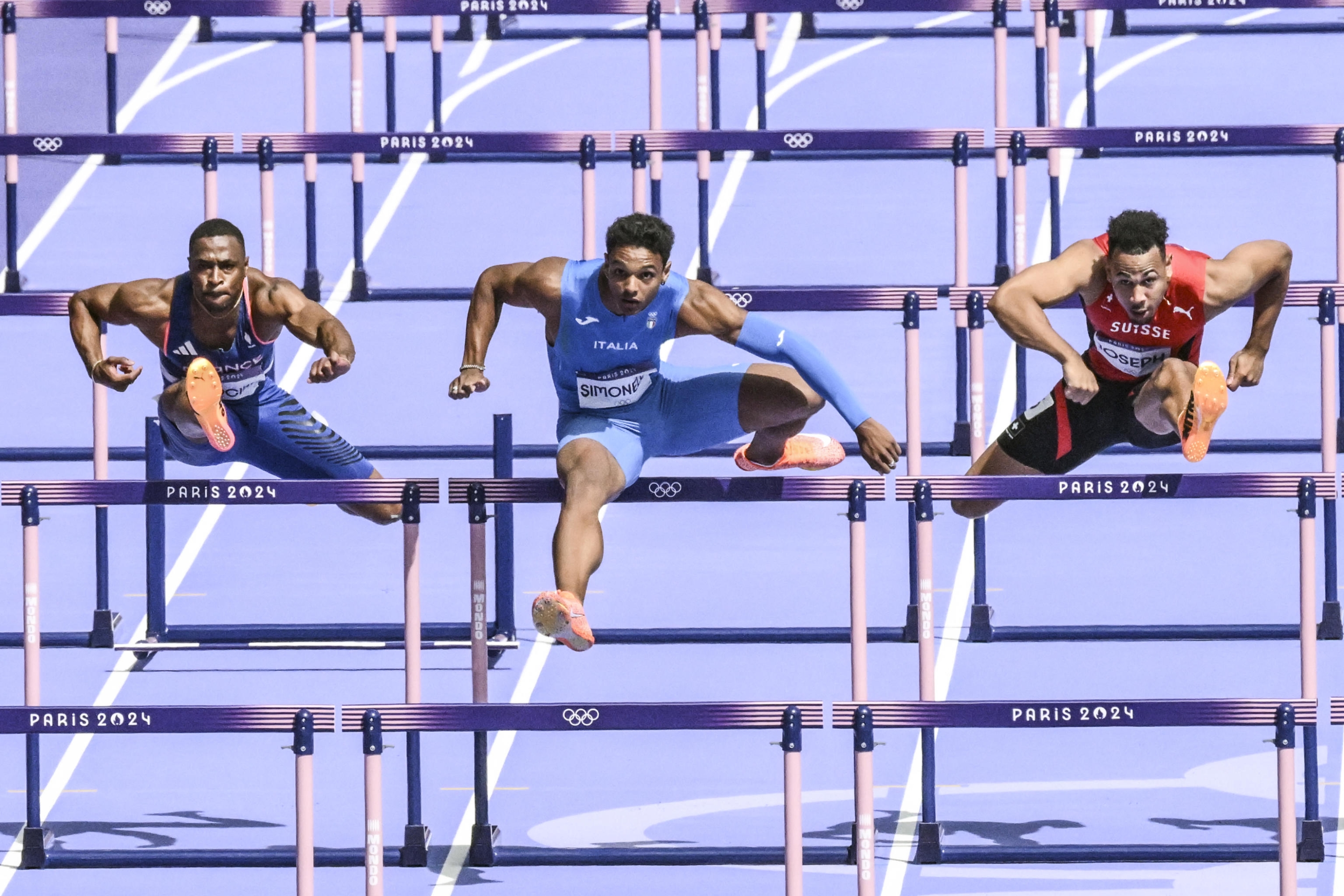 Italian Lorenzo Simonelli (C) in action during the qualifying race for the semi-finals of the 110 Obstacles at the Paris 2024 Olympic Games, in the Stade de France, 04 August 2024.   ANSA / CIRO FUSCO