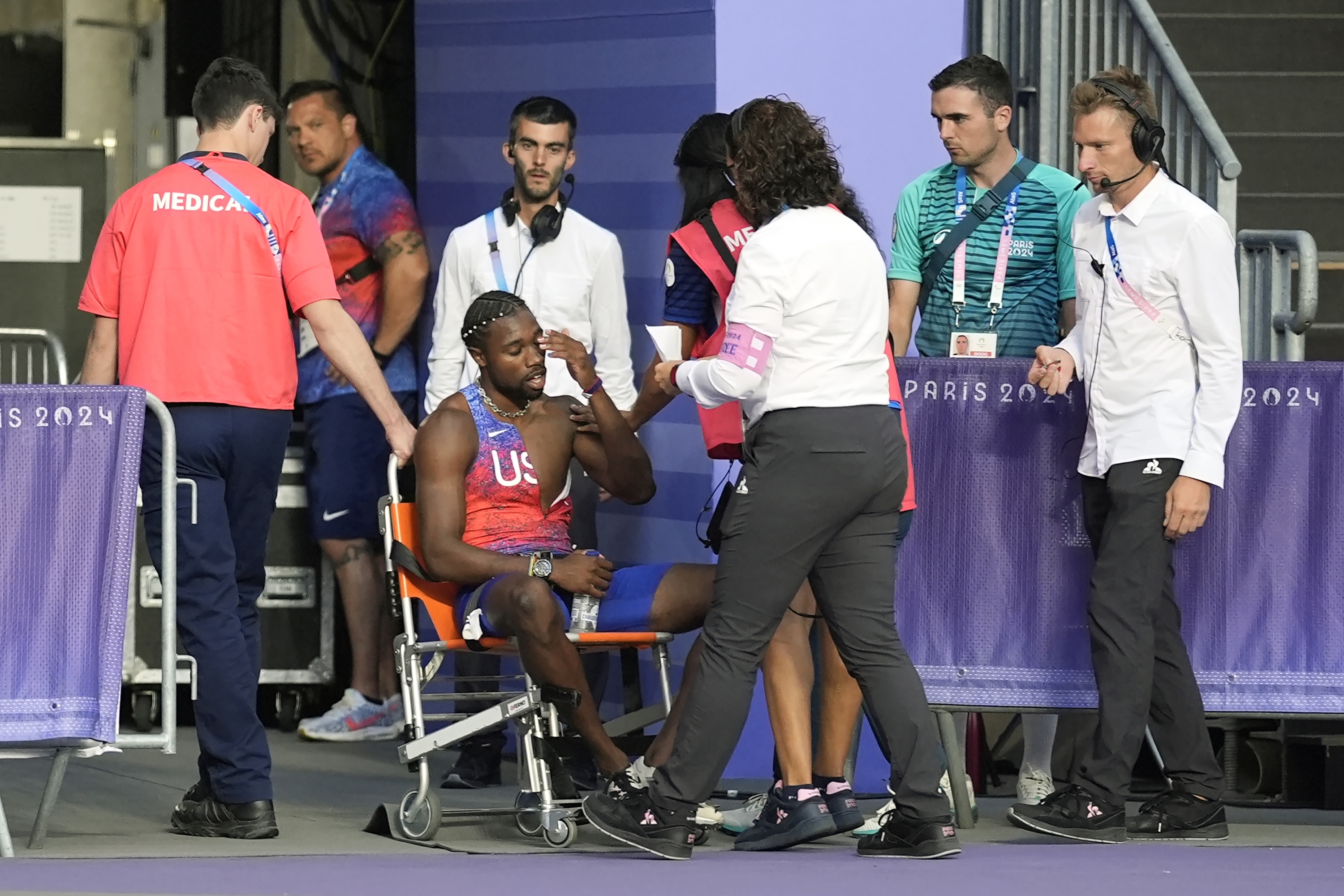 Noah Lyles, of the United States, is helped off the track after the men's 200-meter final at the 2024 Summer Olympics, Thursday, Aug. 8, 2024, in Saint-Denis, France. (AP Photo/Matthias Schrader)