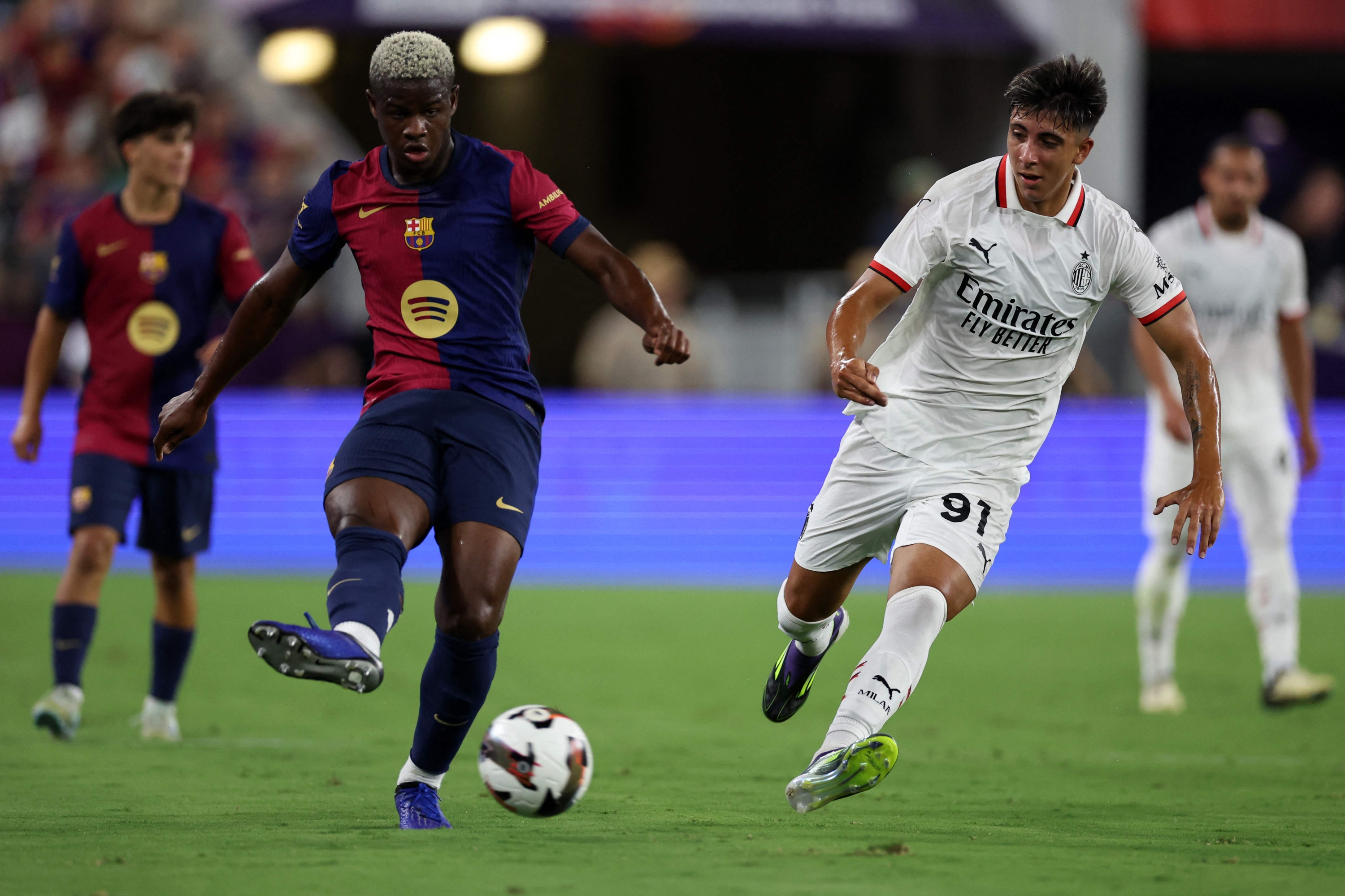 BALTIMORE, MARYLAND - AUGUST 06: Mikfayil Faye of FC Barcelona drives the ball against Hugo Cuenca of AC Milan during a Pre-Season Friendly match between FC Barcelona and AC Milan at M&T Bank Stadium on August 06, 2024 in Baltimore, Maryland.   Scott Taetsch/Getty Images/AFP (Photo by Scott Taetsch / GETTY IMAGES NORTH AMERICA / Getty Images via AFP)