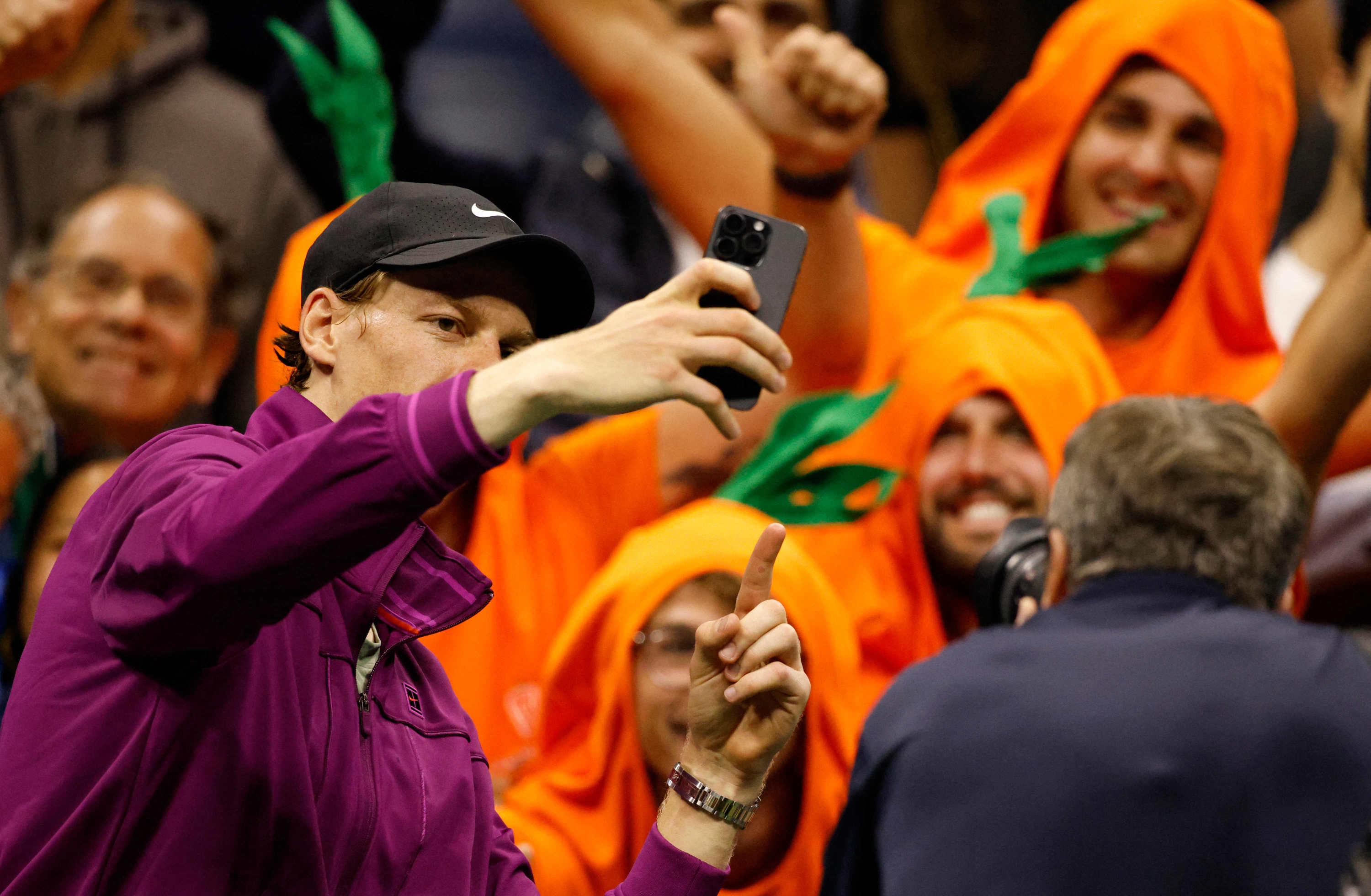 TOPSHOT - Italy's Jannik Sinner takes a selfie with his orange-clad fans "Carota Boys" after he defeated Russia's Daniil Medvedev in the men's quarterfinals match on day ten of the US Open tennis tournament at the USTA Billie Jean King National Tennis Center in New York City, on September 4, 2024. (Photo by Kena Betancur / AFP)