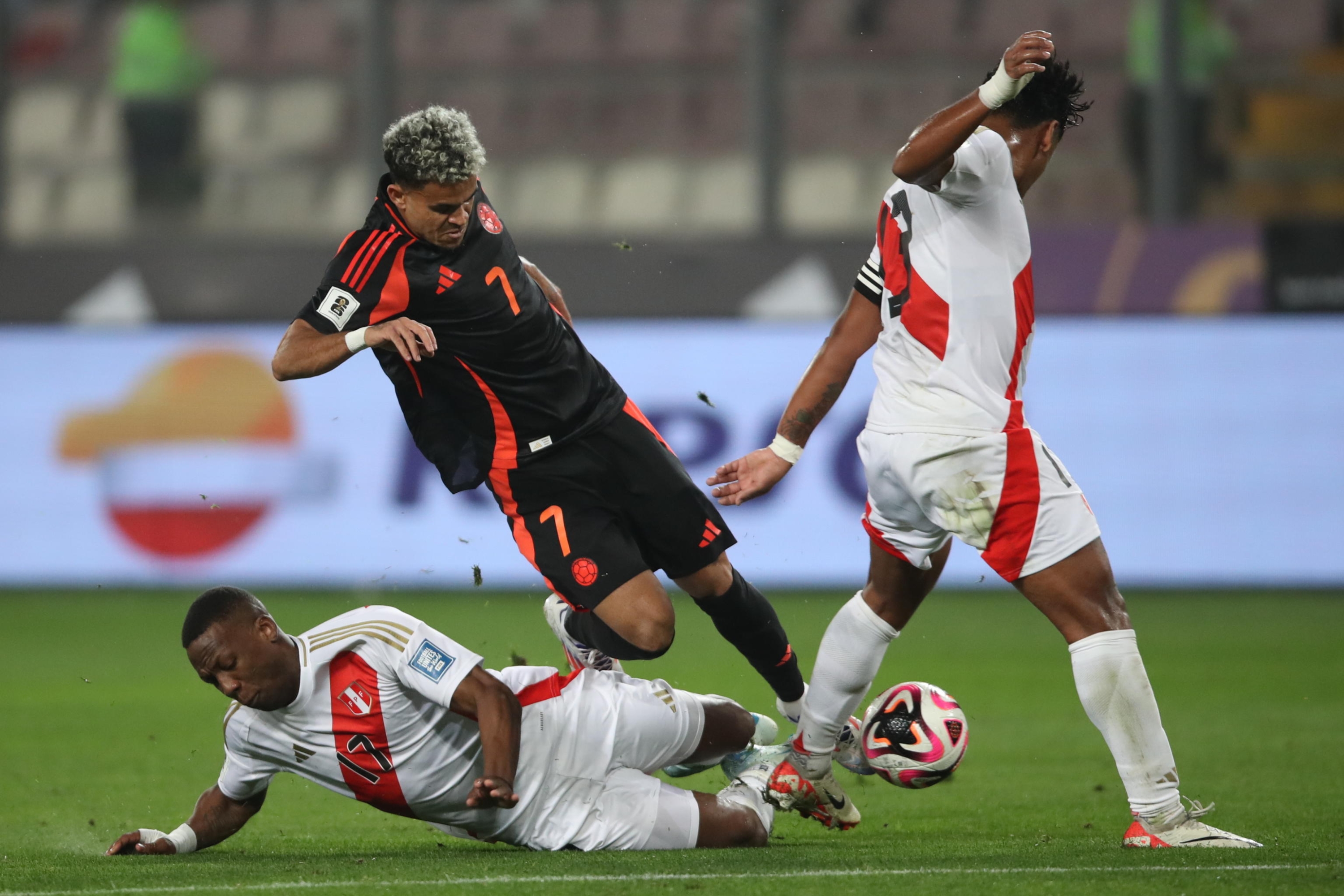 epa11590716 Luis Advincula (L) of Peru in action against Luis Diaz (C) of Colombia during the CONMEBOL FIFA World Cup 2026 qualifier between Peru and Colombia at the Nacional Stadium in Lima, Peru, 06 September 2024.  EPA/Paolo Aguilar