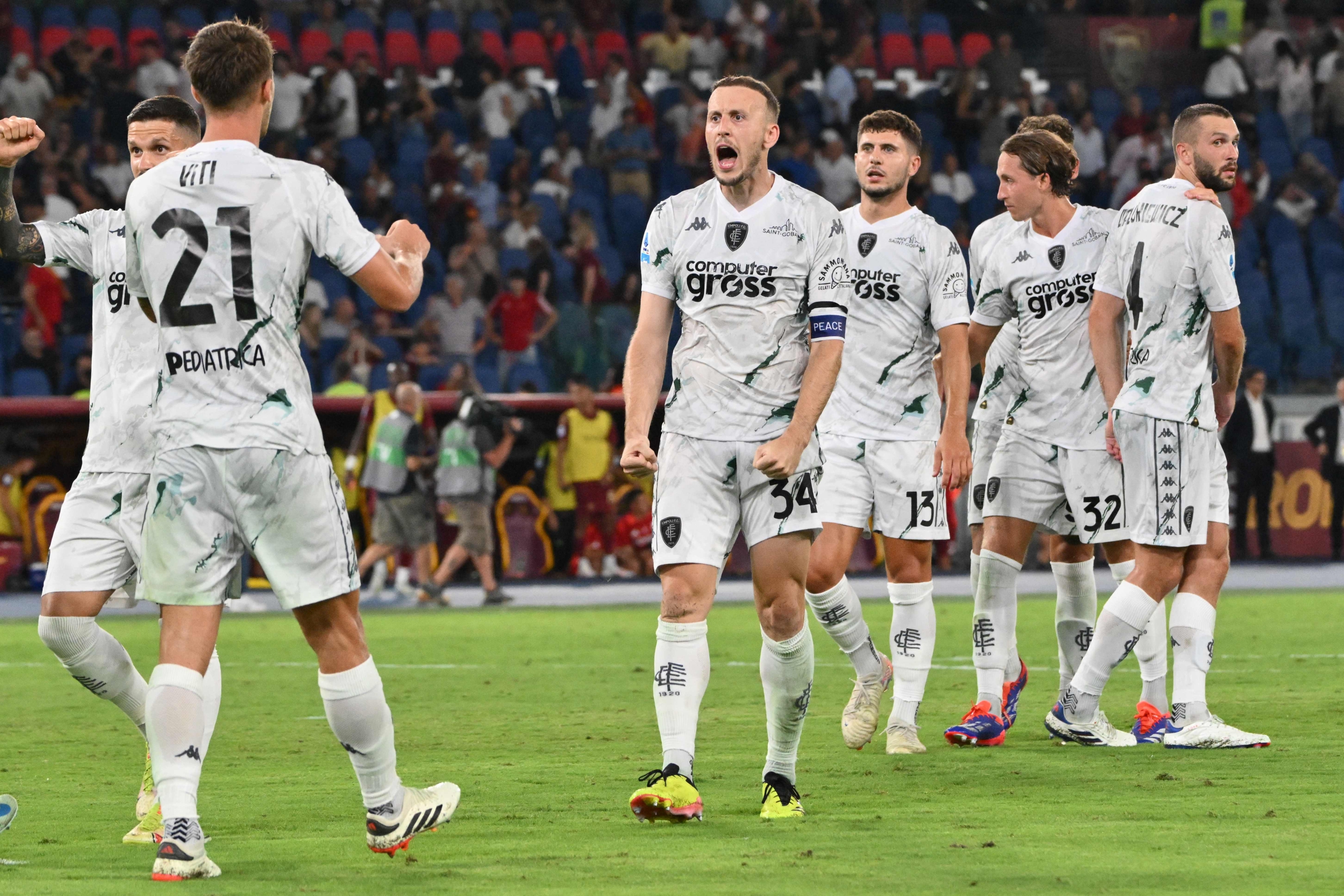 Empoli's Albanian defender #34 Ardian Ismajli celebrates with his teammates after winning at the end of the Italian Serie A football match AS Roma against Empoli at Olympic stadium, in Rome on August 25, 2024. (Photo by Alberto PIZZOLI / AFP)