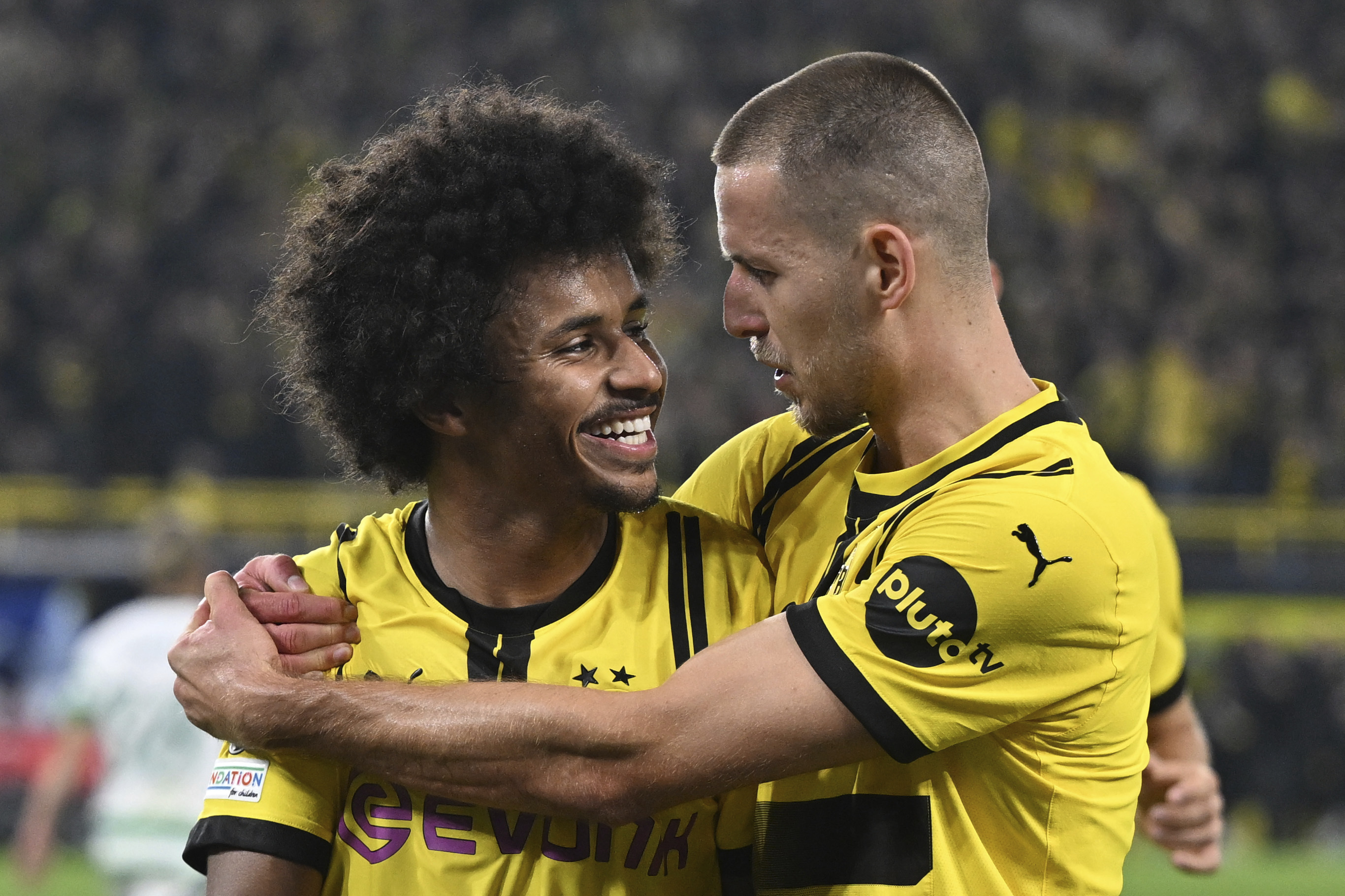 Dortmund's Karim Adeyemi, left, celebrates with Waldemar Anton, after scoring his side's third goal during the Champions League opening phase soccer match between Borussia Dortmund and Celtic FC in Dortmund, Germany, Tuesday, Oct. 1, 2024.  (Bernd Thissen/dpa via AP)